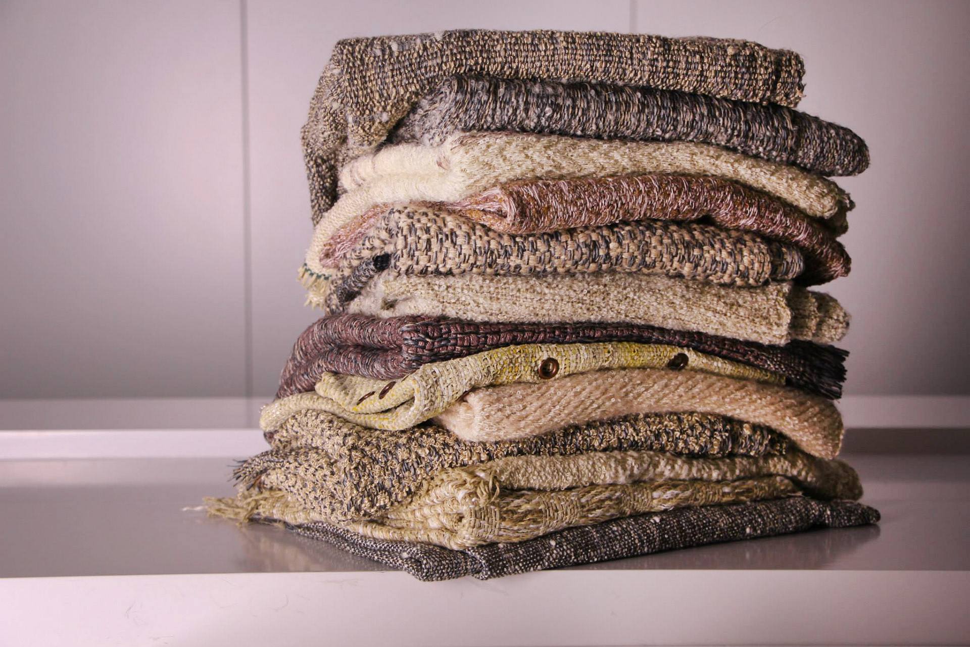 Stack of handwoven textured upholstery fabrics with a rustic charm