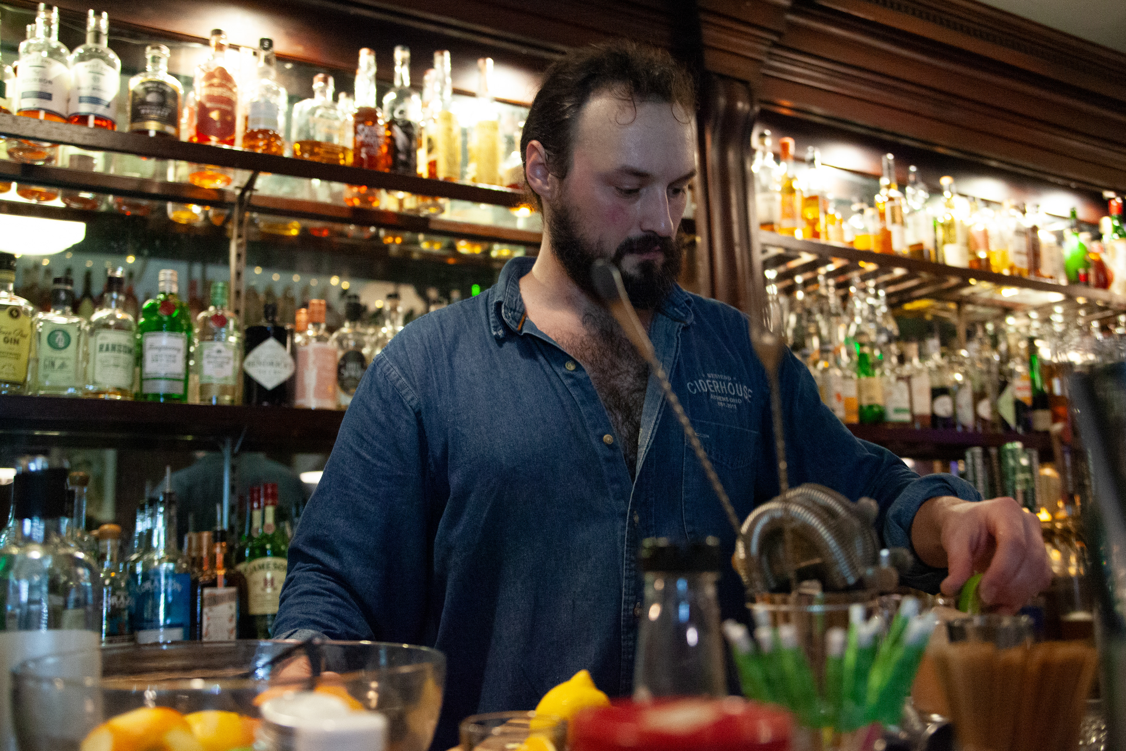 Matt Waite, a bartender at West End Ciderhouse, squeezes a lime to prepare a drink for a customer on West Washington Street, Feb. 16, 2024 in Athens, Ohio. The ciderhouse sells alcoholic cider made from Ohio grown apples as well as a variety of cocktails.