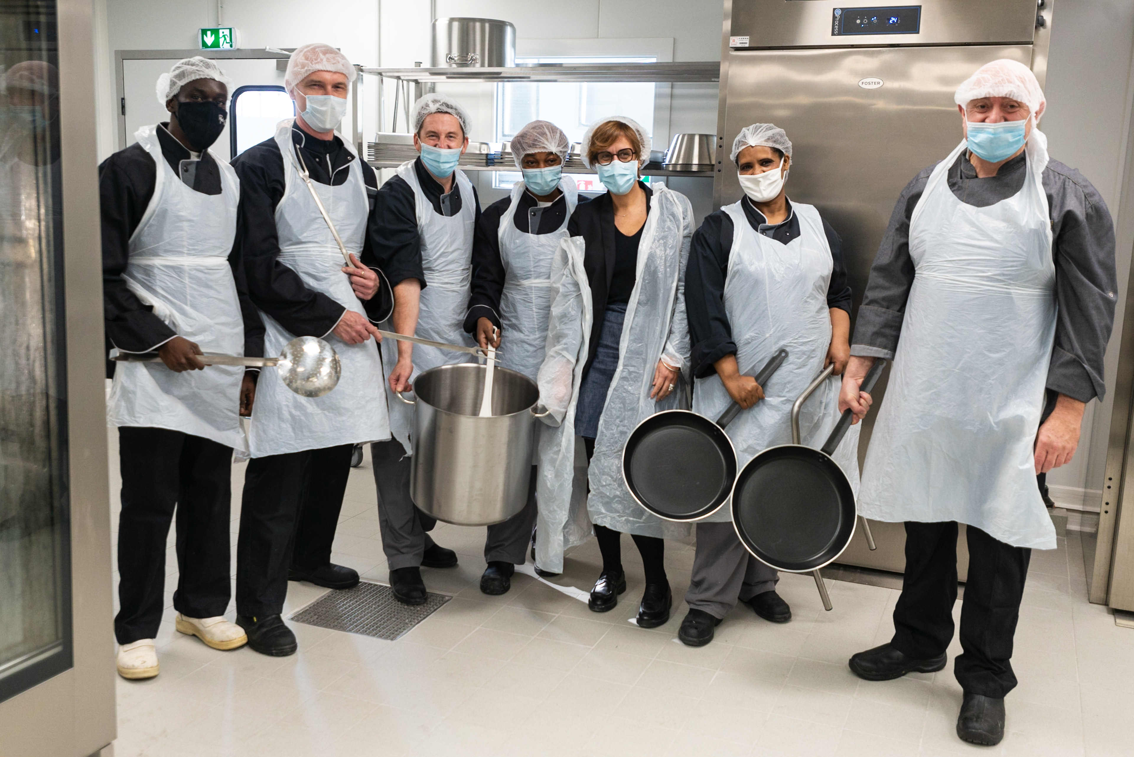 Christine Merckelhagh, fondatrice gérante de Label Gamelle, Vincent Dautry, co-fondateur, et leur équipe le jour du demarrage de l'activité de l'entreprise. Label Gamelle est une cuisine centrale où mitonner des repas de grande qualité pour les plus démunis.Label Gamelle est ainsi une entreprise au service de l’humain qui concilie activité économique et utilité sociale. Une entreprise d'insertion, la grande majorité des employés de Label gamelle sont des personnes recrutées en contrat à durée déterminée d’insertion (CDDI). Montreuil, France.