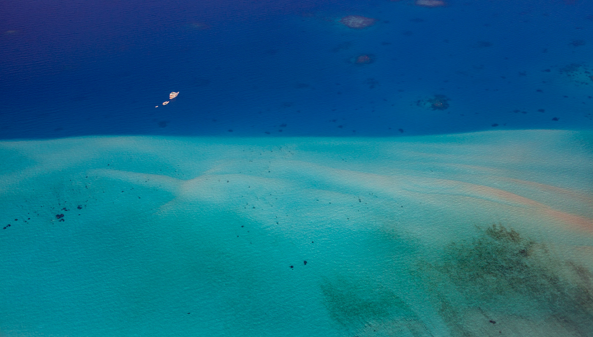Survol en hydravion de l’atoll de Laamu, au sud de l’archipel des Maldives, 3 bateaux en vue