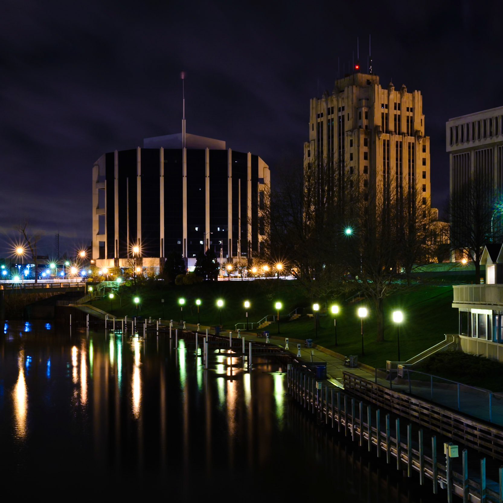 Shot for Week 17 of my "52 of Twenty Eleven" flickr group given the theme of "Architecture"  This is a night shot of Mount Clemens )or "The Clem" as we call it) from a bridge above the Clinton River.The sky was cloudy tonight and there was a little chill in the air, but spring is definitely in the air.  You can see the grass is greening and there's no more snow or ice anywhere to be seen.  Soon enough we'll have leaves on our trees and boats in the water.Check this out on black by clicking "L".  It's worth a look...