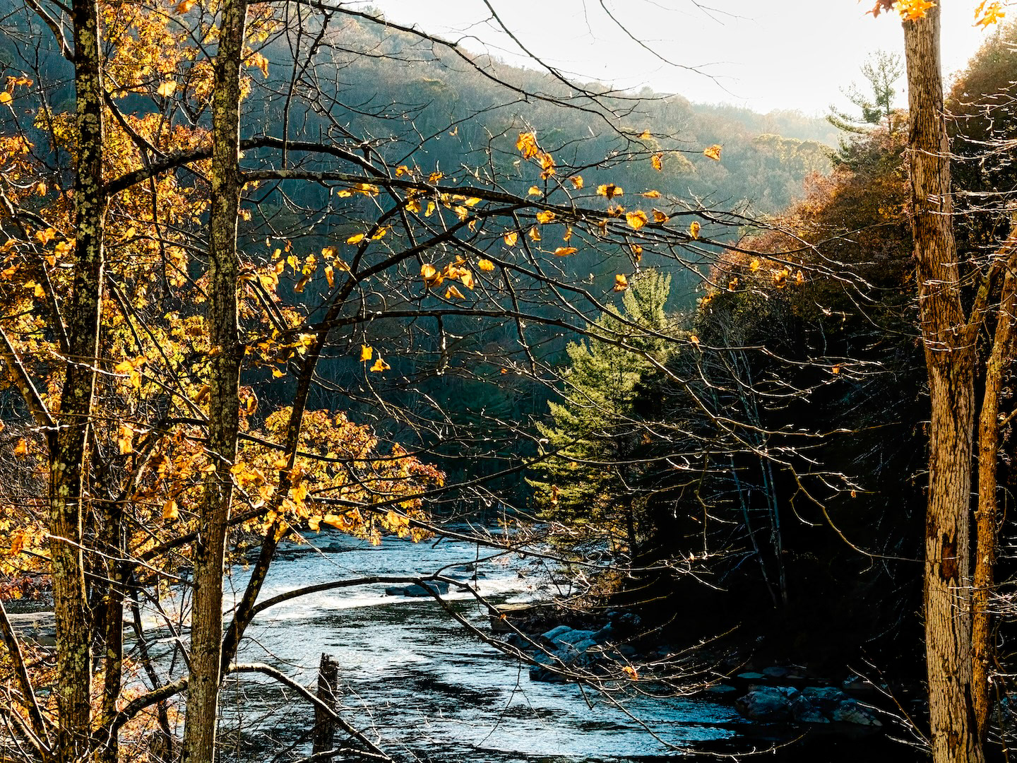 Fall colors adorn the landscape surrounding the winding Youghiogheny River in Ohiopyle, Pennsylvania.