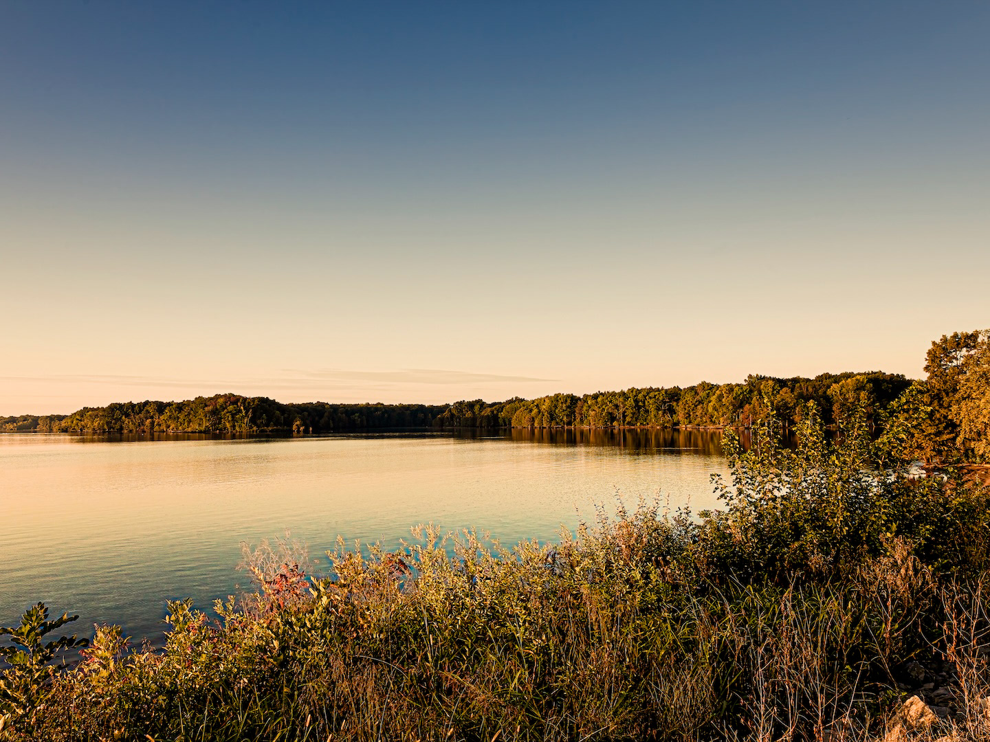 A tranquil morning view at Rend Lake, Illinois, likely featuring calm waters reflecting the early light, with tree-lined shores or open water stretching towards the horizon under a soft sky.
