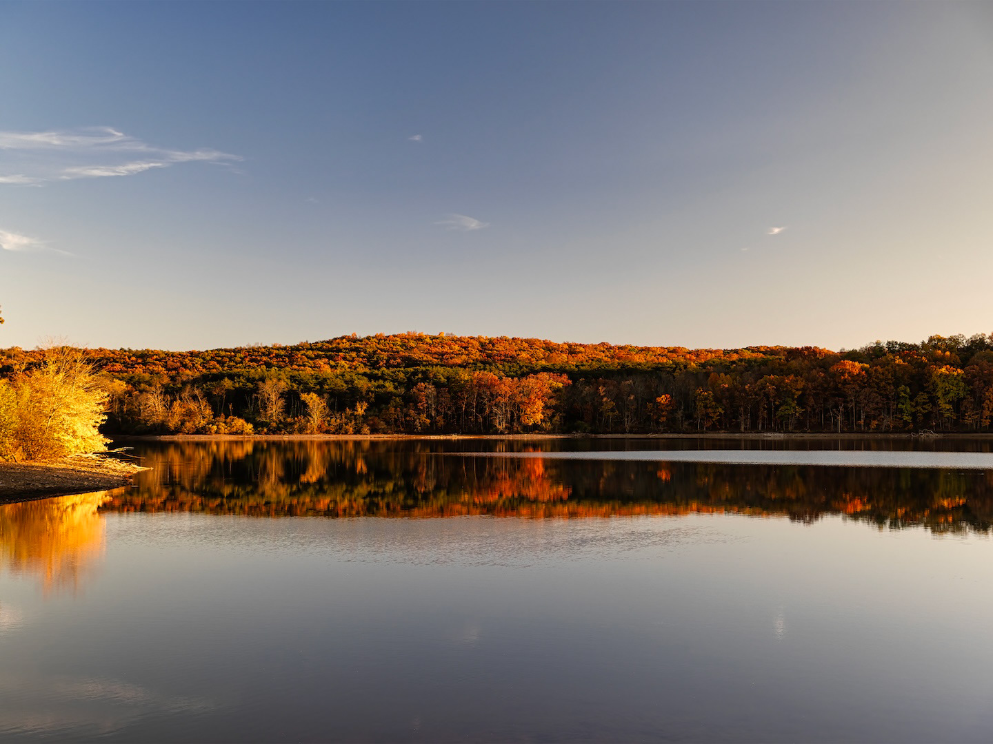 Beautiful autumn view of lake, trees, and hills.
