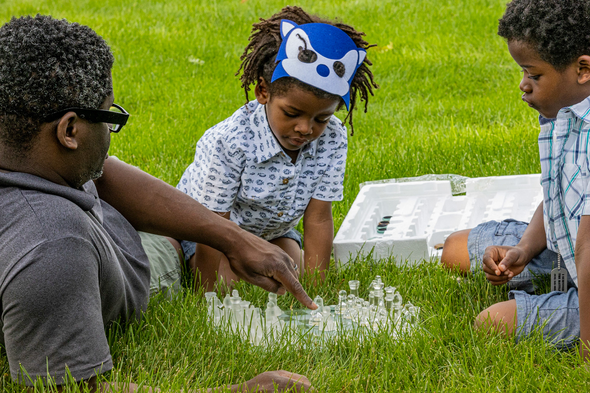 Asante teaching his sons chess, Lansing, MI