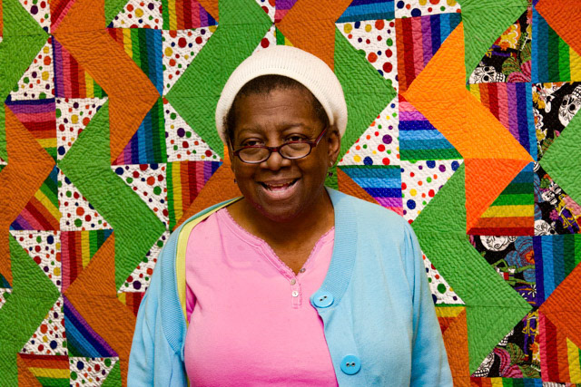 Mama Jackie, standing in front of one of her prize winning quilts