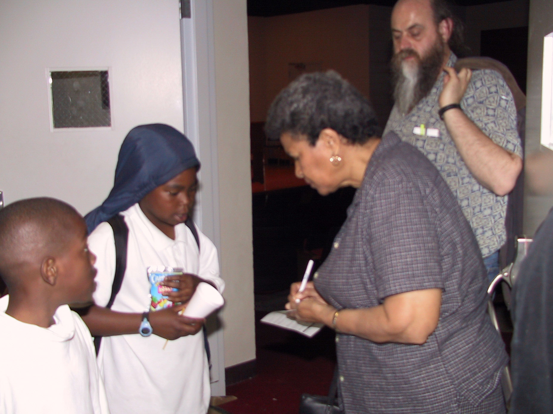 Malcolm X's youngest sister, Yvonne, signing autographs for Shabazz Academy students