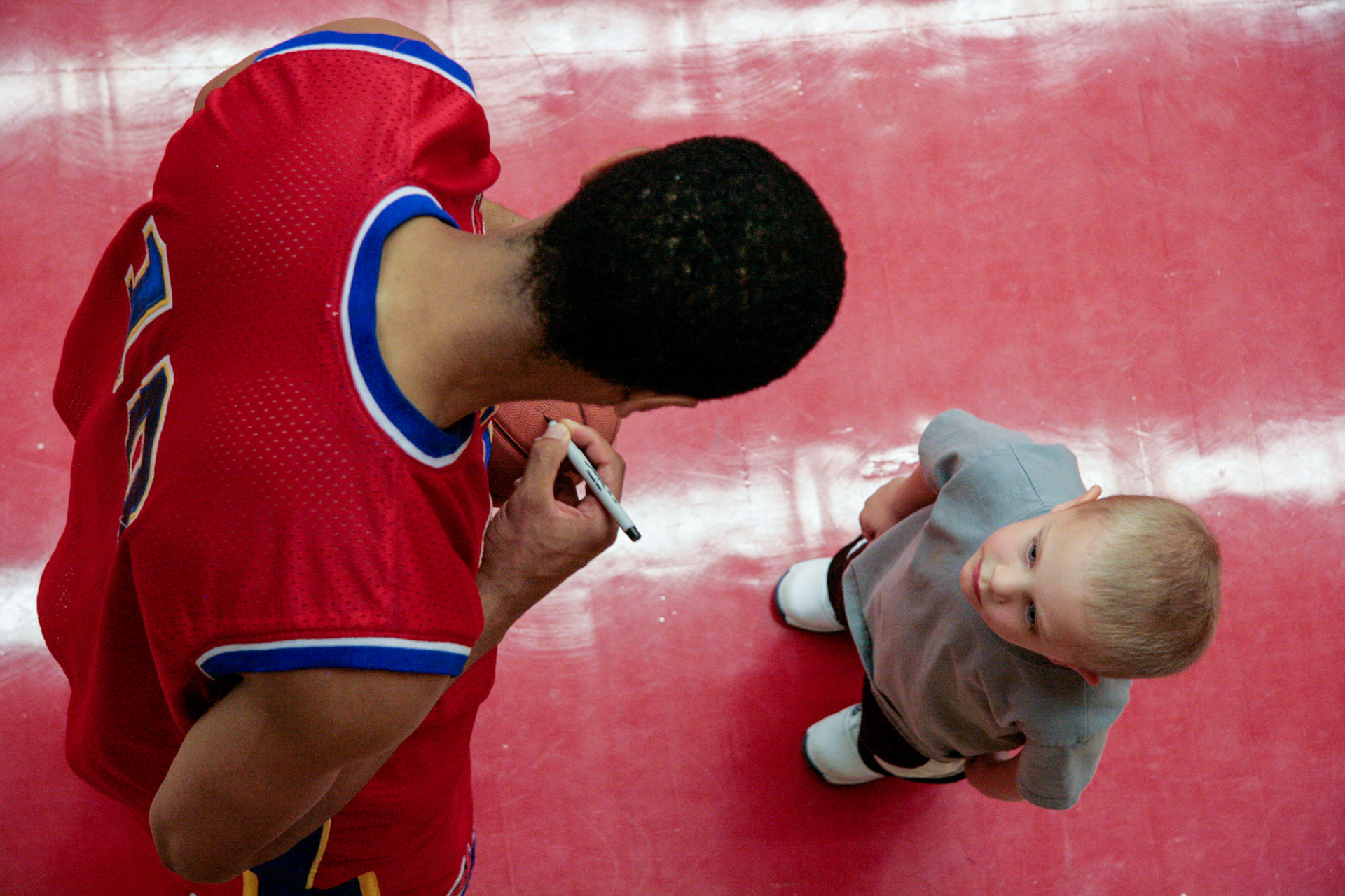 Young boy awaits an autograph from a player with the International Basketball League.