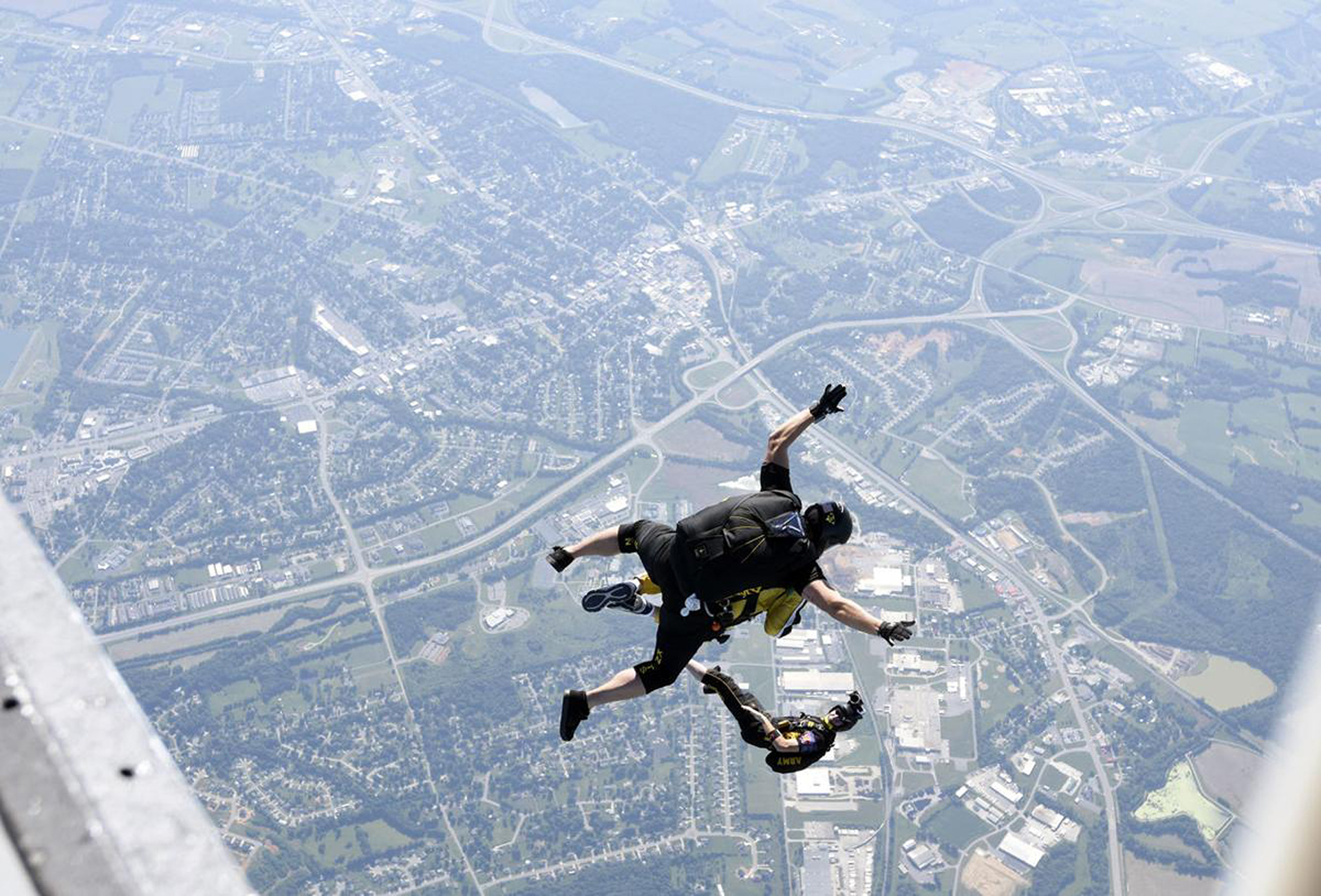 A member of the Golden Knights, the U.S. Army's parachute team, looks back Saturday, June 16, 2018, and records a fellow Golden Knight jumping tandem with an ROTC supporter during a jump sponsored by the U.S. Army Cadet Command as part of the Centers of Influence program at Elizabethtown Regional Airport at Addington Field in Elizabethtown, Kentucky. (Jill PIckett/The News-Enterprise)