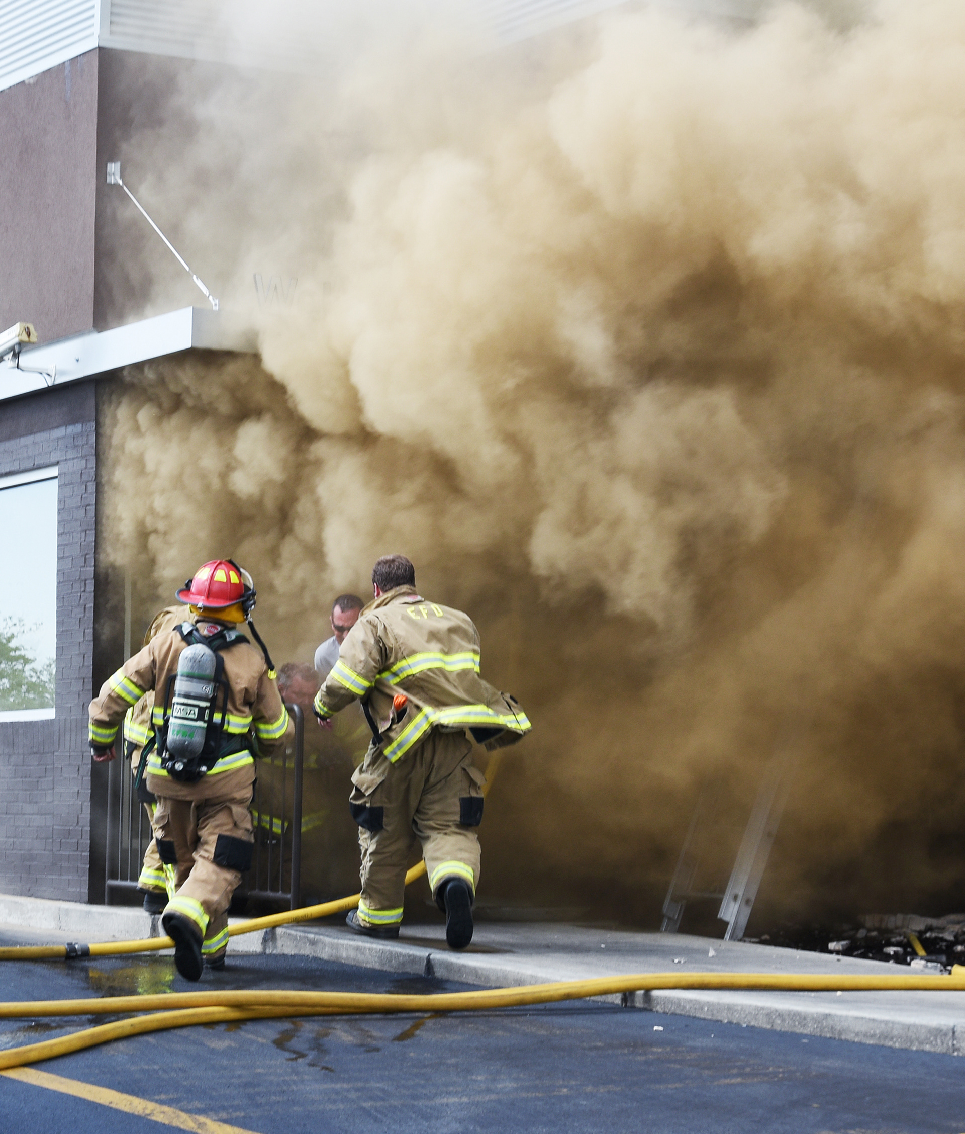 Firefighters rush to the aid of a fellow firefighter on his knees after exiting the McDonald's by Towne Mall in Elizabethtown, Kentucky, Thursday, June 16, 2016. (Jill Pickett/The News-Enterprise) 