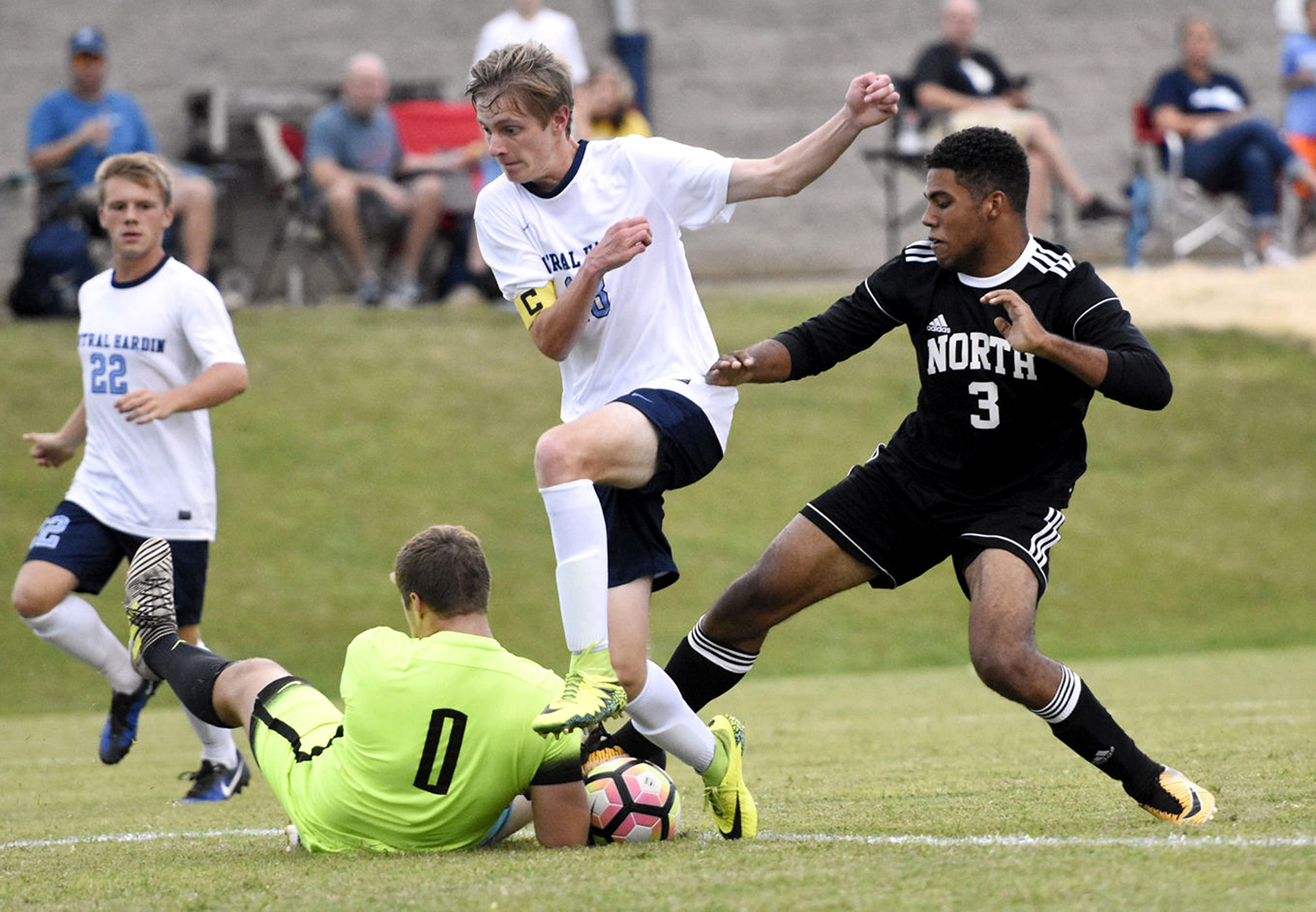 Central Hardin goalie Garrett Schall tries to grab the ball before North Hardin's Seth Taylor can shoot as Central Hardin's Eli Best jumps over him during 17th District action Thursday, Aug. 31. 2017 at Central Hardin High School. (Jill PIckett/The News-Enterprise)