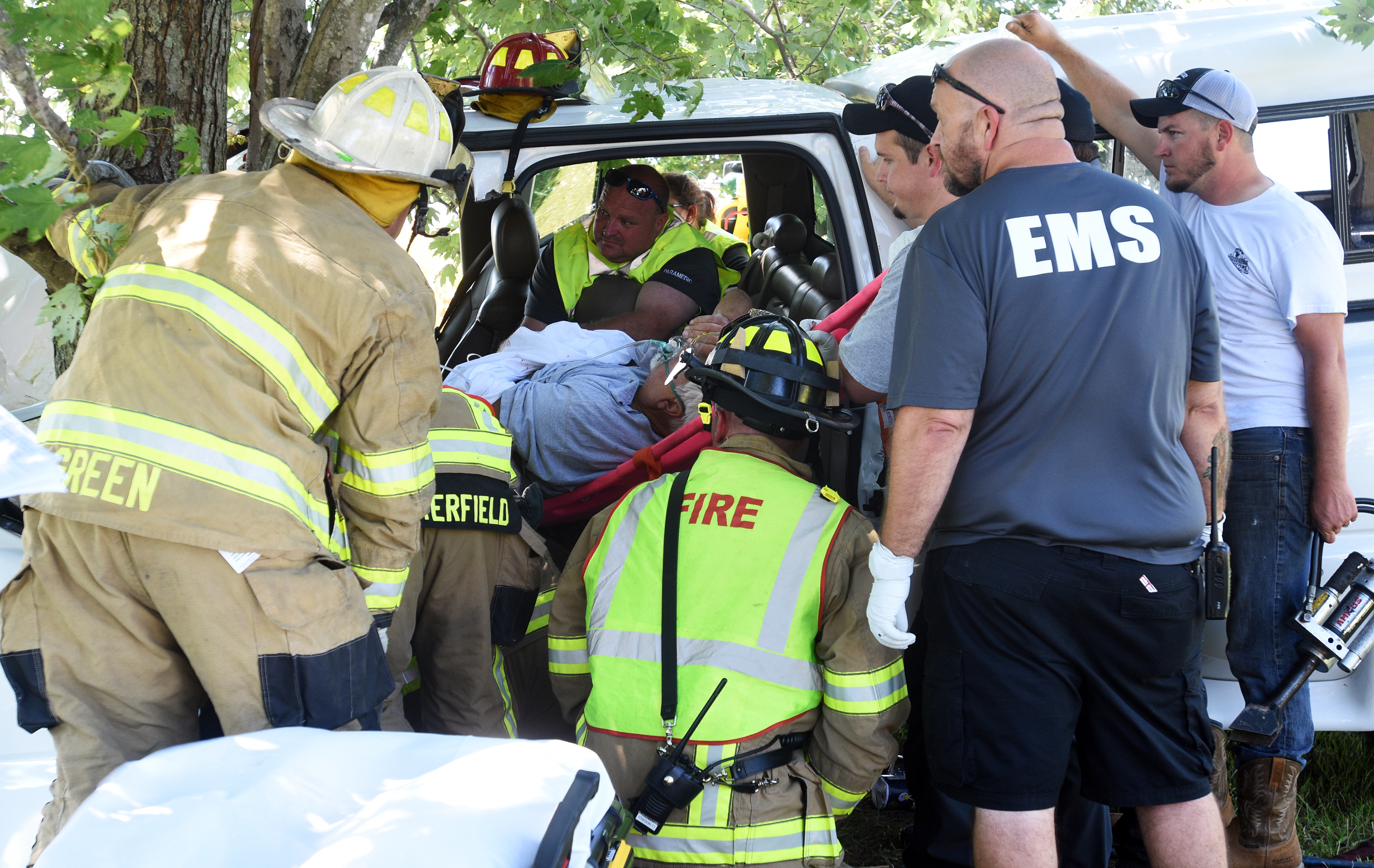 First responders attend to and work to free a man from the driver's seat of a truck Friday, Sept. 2, 2106, after the truck collided with a tree along Middle Creek Road in the Valley Creek area of Hardin County, Kentucky. The man and his passenger were flown from the scene to Louisville. (Jill Pickett/The News-Enterprise)