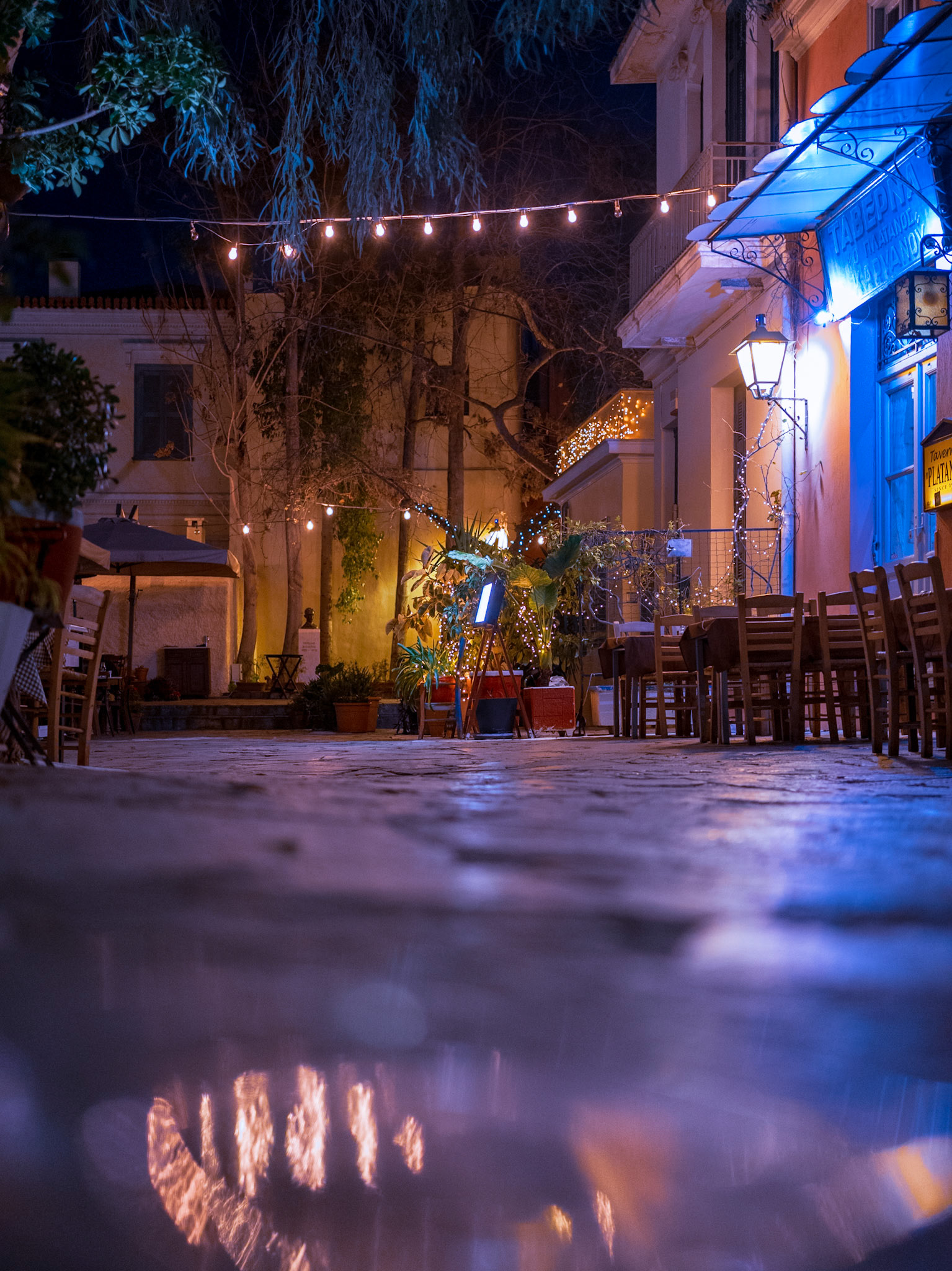 A hidden path of #lights ✨If you find yourself in #Athens downtown, you might want to pay a visit at this picturesque part of the city 🌃Being in #Plaka and its marble-paved alleys, you'll find quite a few spots to get a gorgeous #nightstreetphotography capture, to show off your visit there 😁One of them, is located close to the Roman Agora 🏛️, that leads to a local tavern!At around 20:00, before people start to crowd in, is the ideal time to take a few shots of this beautiful alley, with its #hanginglights, and the colorful decoration!With a bit of patience and trials and errors, I bet you'll leave this place with something much more memorable than a souvenir 😋ℹ️ Street Photography Tip: Shiny objectsHere's how I got this glare in this shot:Close to this tavern, I came upon a plastic transparent plate, on the ground! By getting low and close,and after a while, experimenting, I got this result!This technique is especially useful for an additional shining in your frame 💫🔖 Save this and try it on your next shoot 📸
