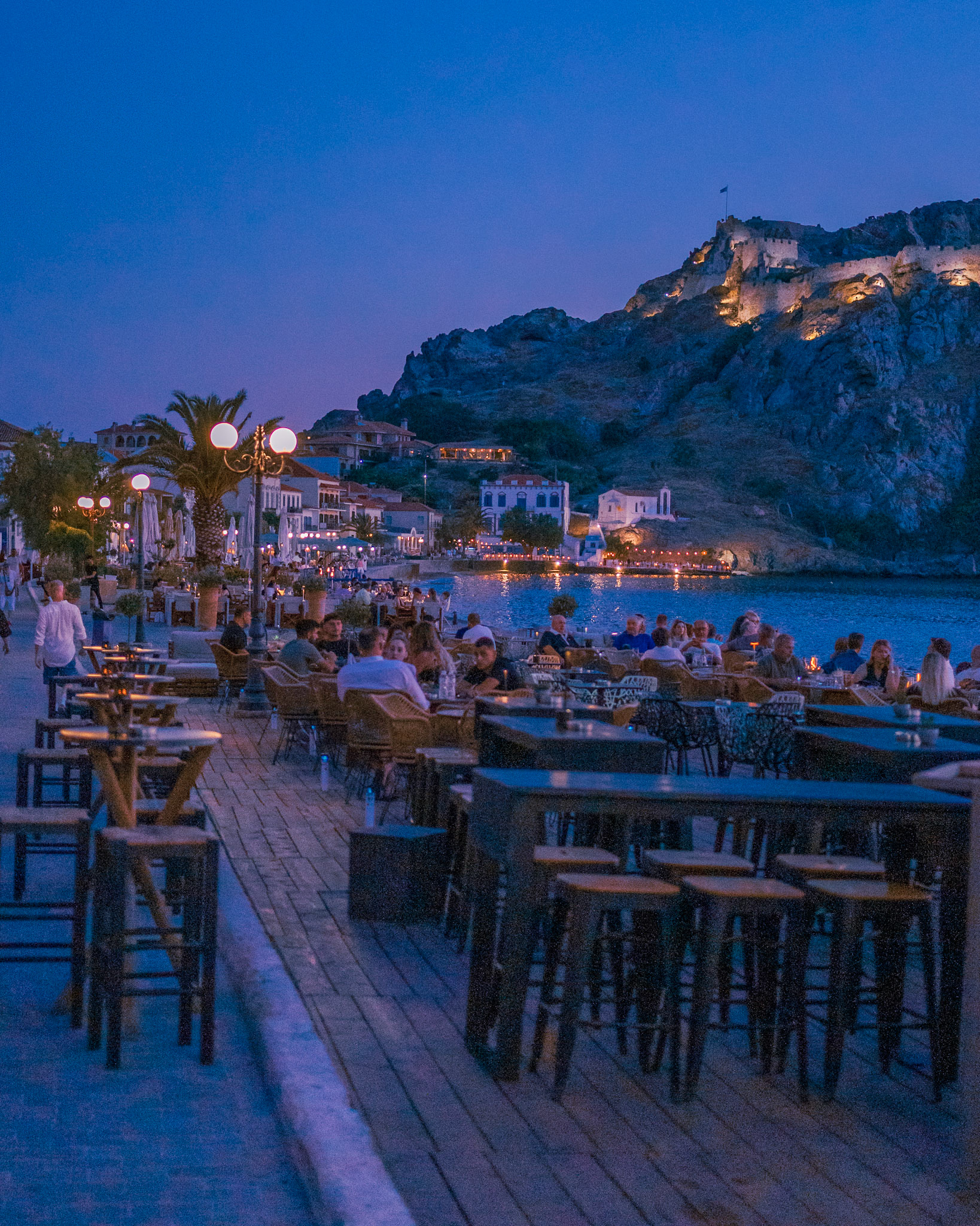As #night✨ approaches, and the last hues of #dusk spread across the city of #Myrima, people already started their #nightout🍸 in #Lemnos 🏝️, with the #castle's 🏰 lights shining on 💎