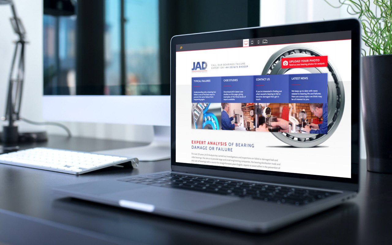 Laptop showing the homepage of JAD Analysis (Bearing Failure Experts)