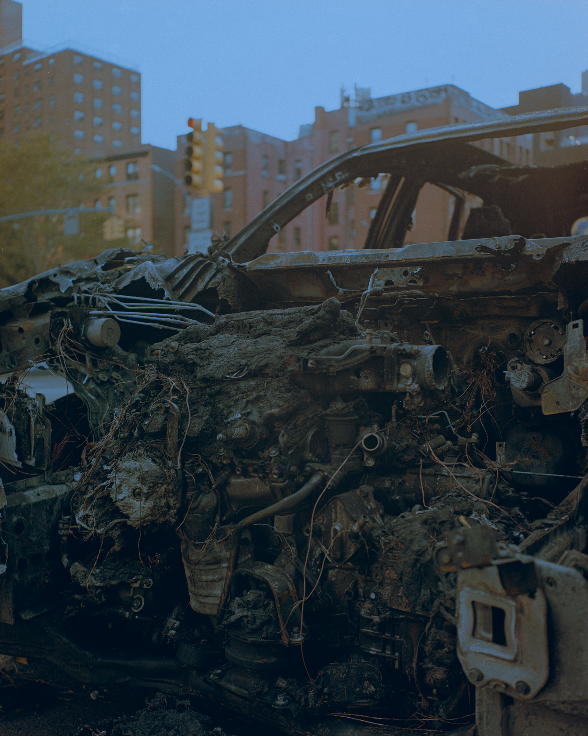 plastic melted on the engine of a burned out car on E Houston St, NYC