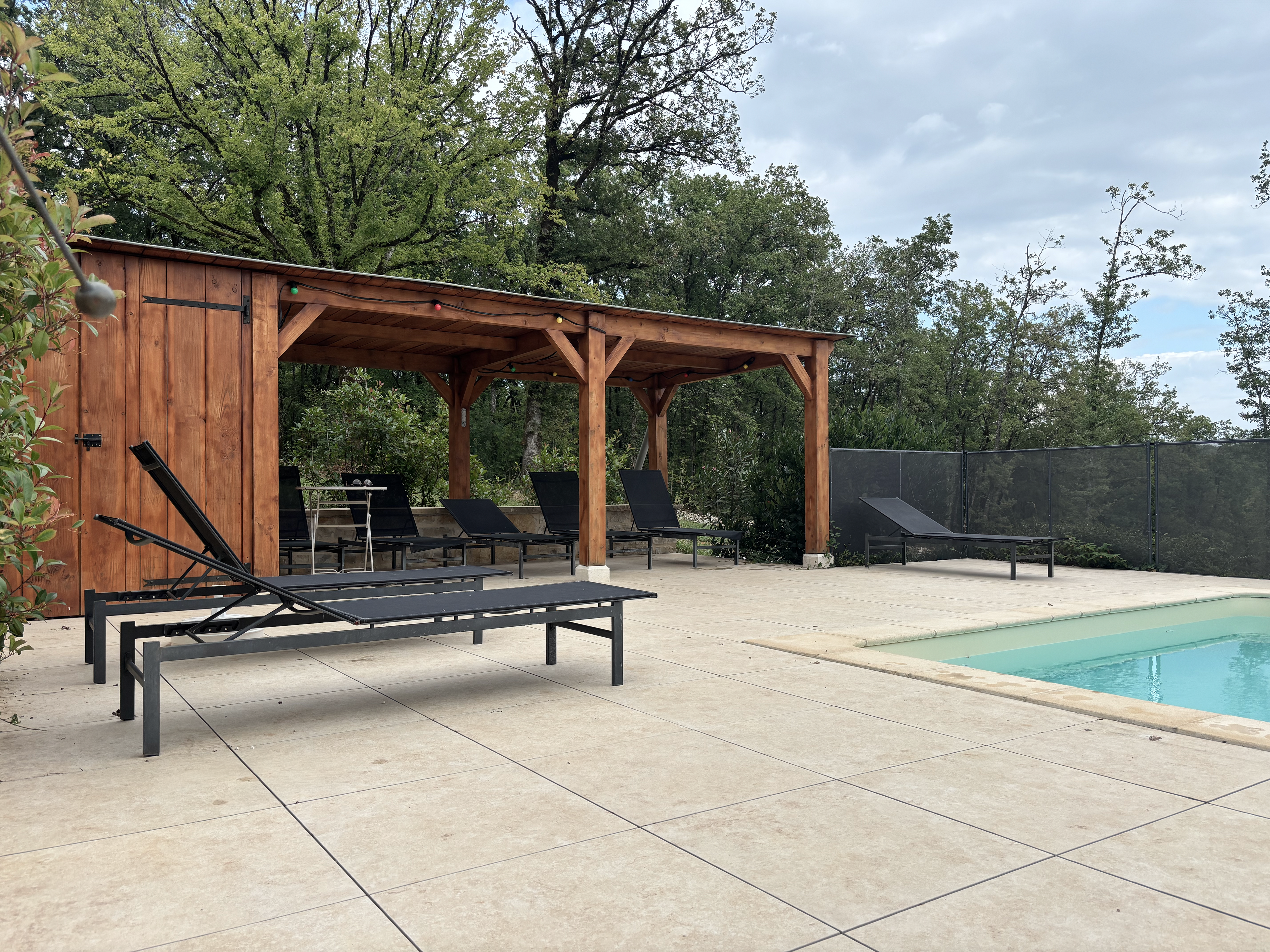 Pergola en bois et local de stockage en bord de piscine