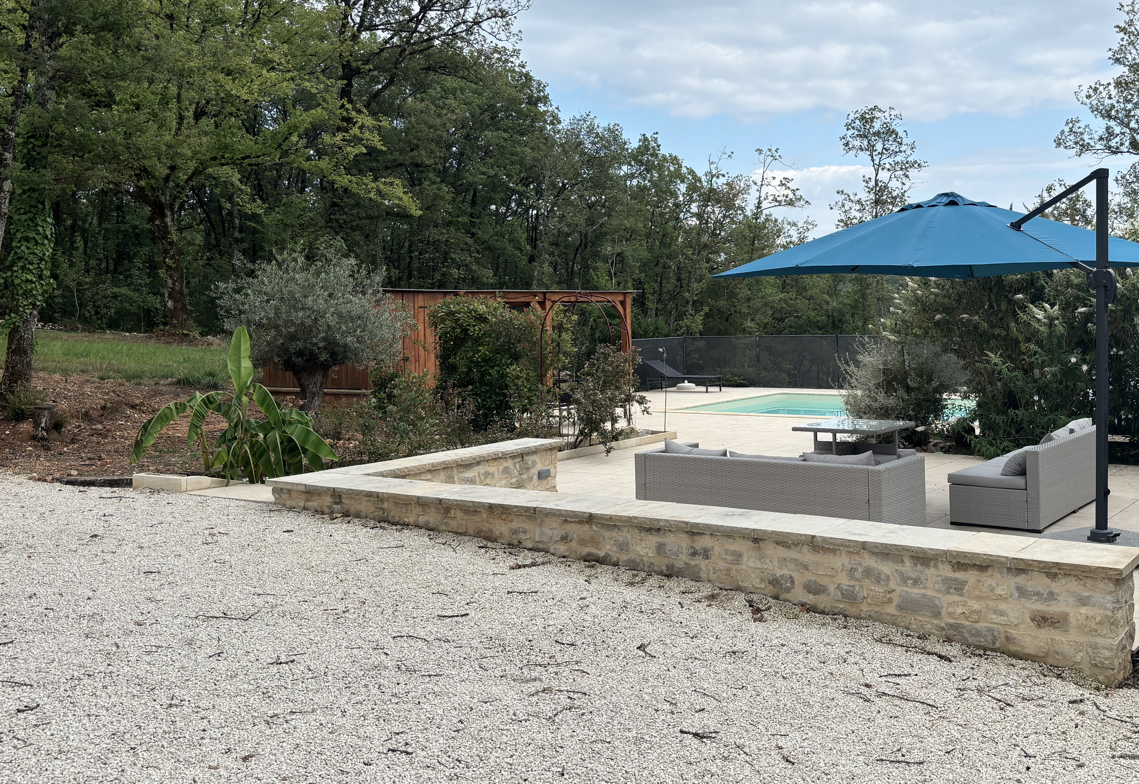 Terrasse avec salon extérieur et piscine en second plan