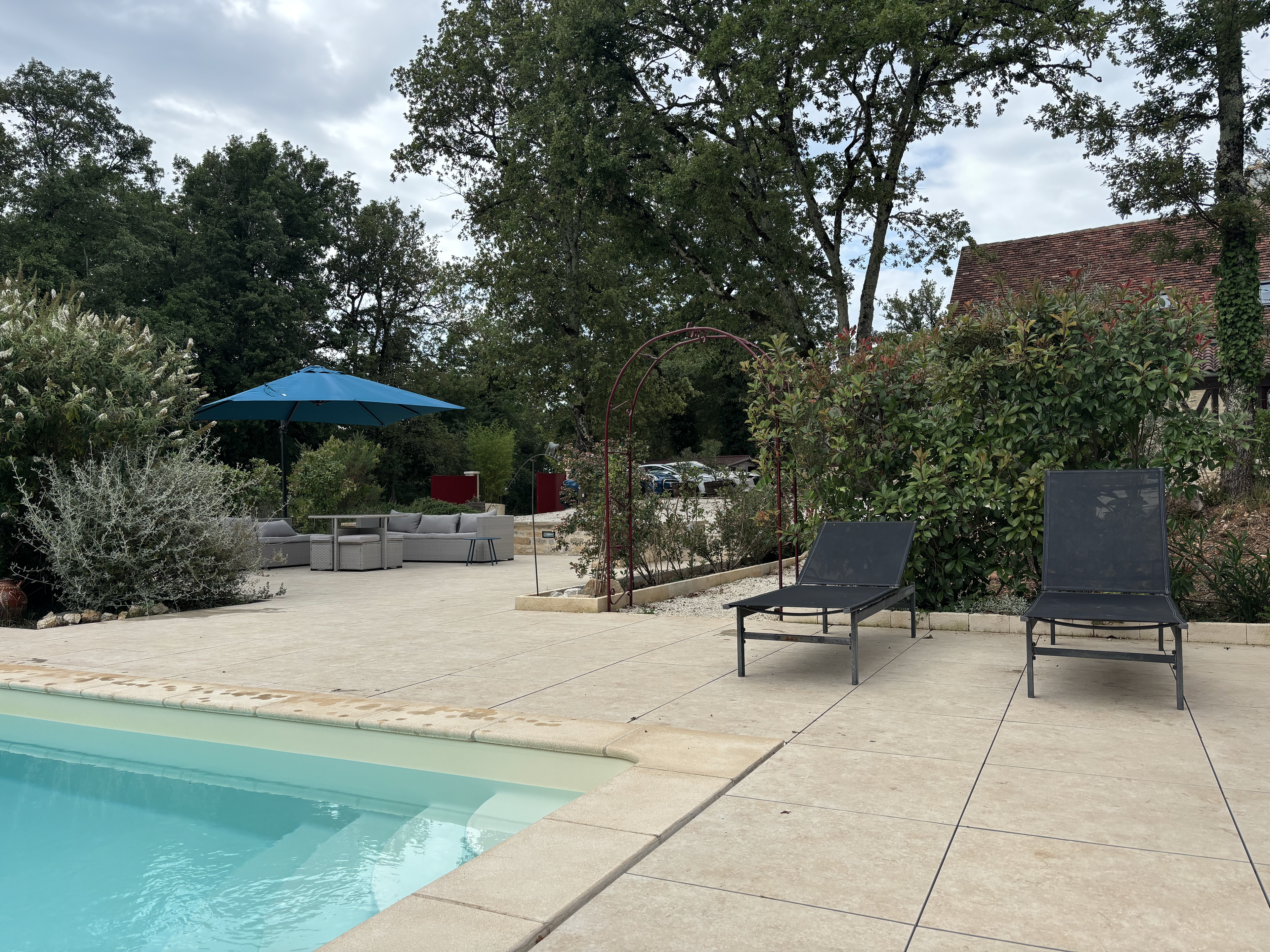 Abords de la piscine avec transats et terrasse minérale