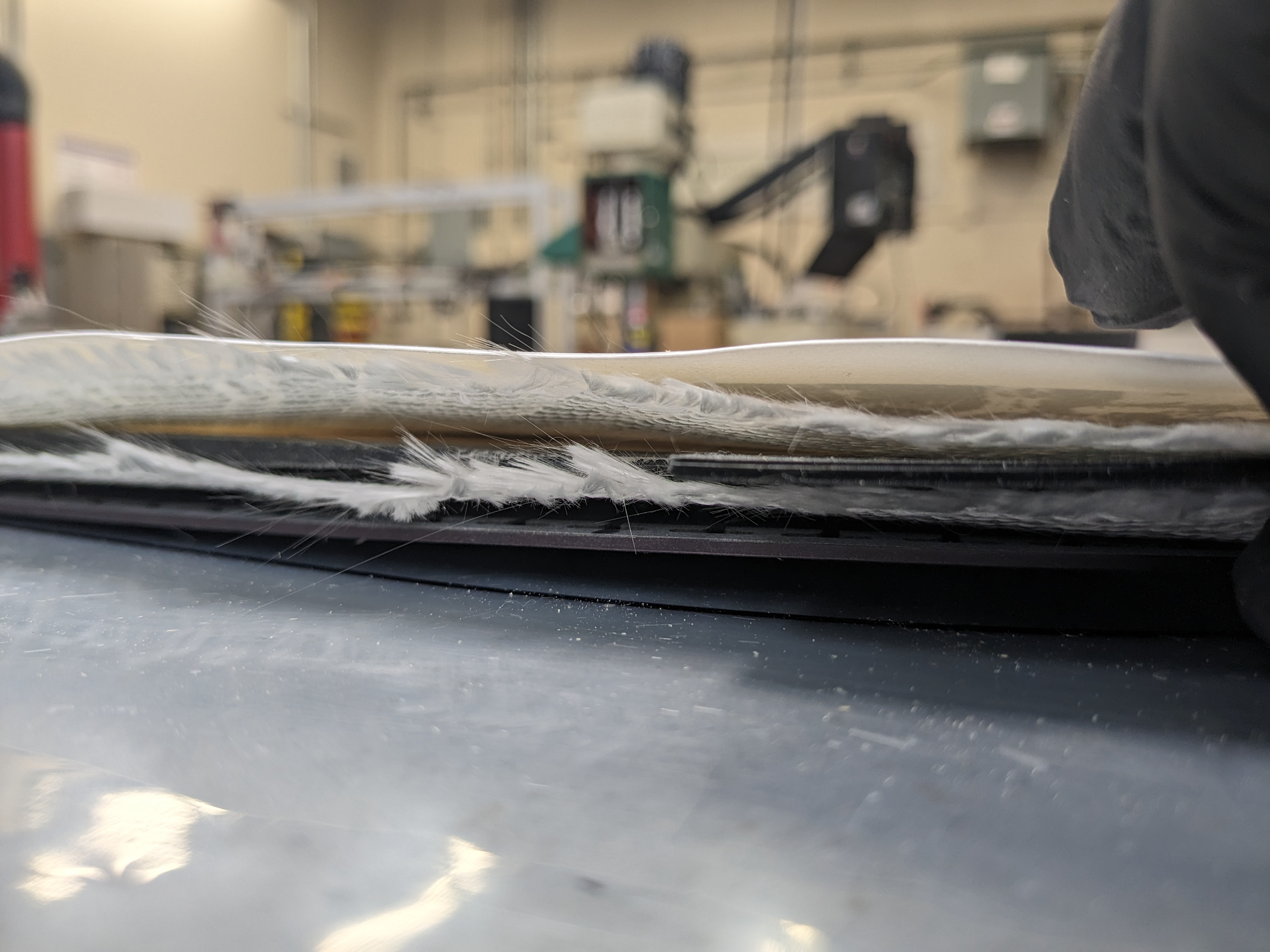 Base, fiberglass, carbon tows + core + sidewalls + tip fillers + edges, fiberglass, top sheet.