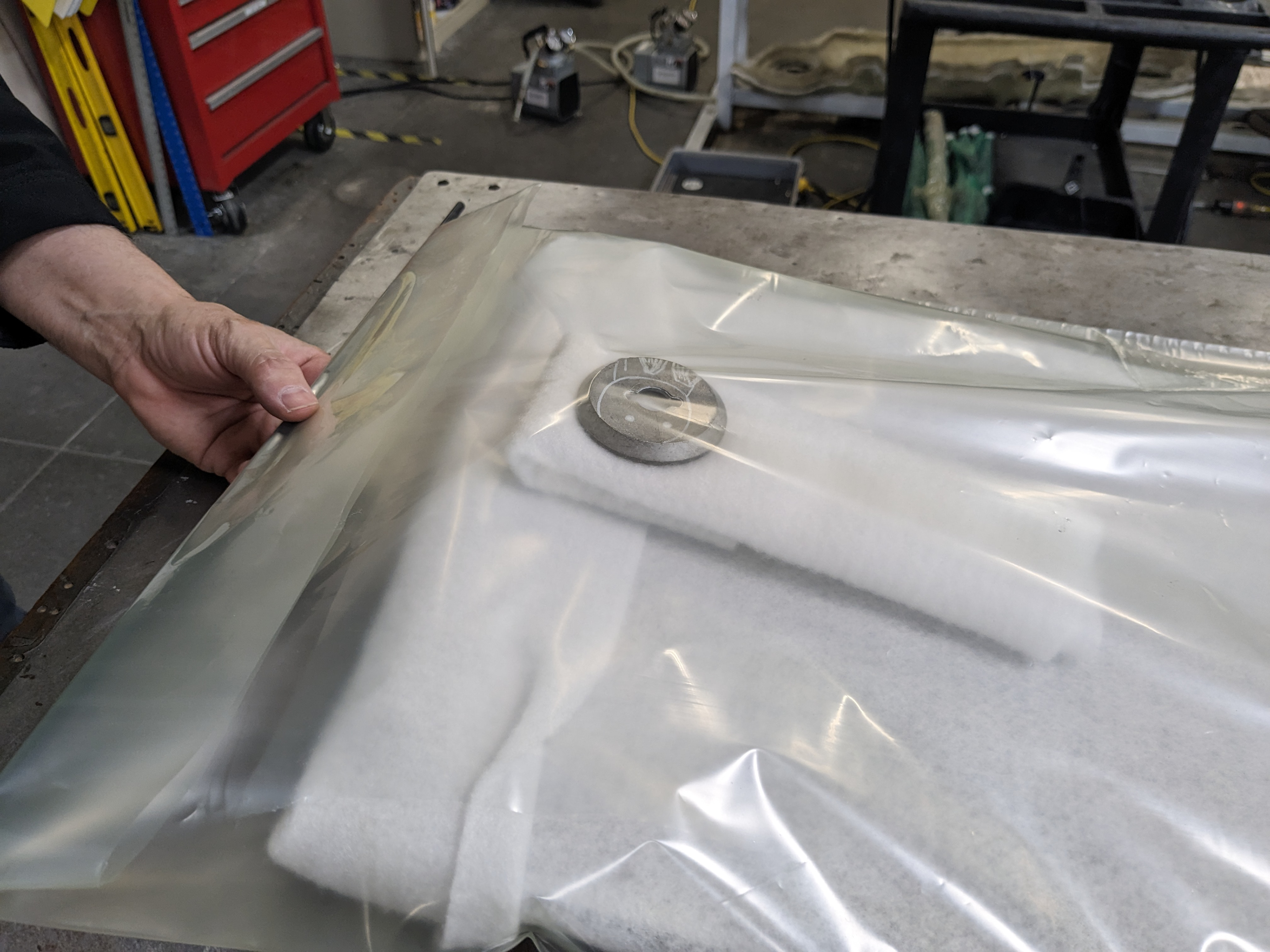 Vacuum bag, commercially they don't use vacuum bags. Vacuum bags are less time efficient, but should get you a lighter board with better squeeze out.