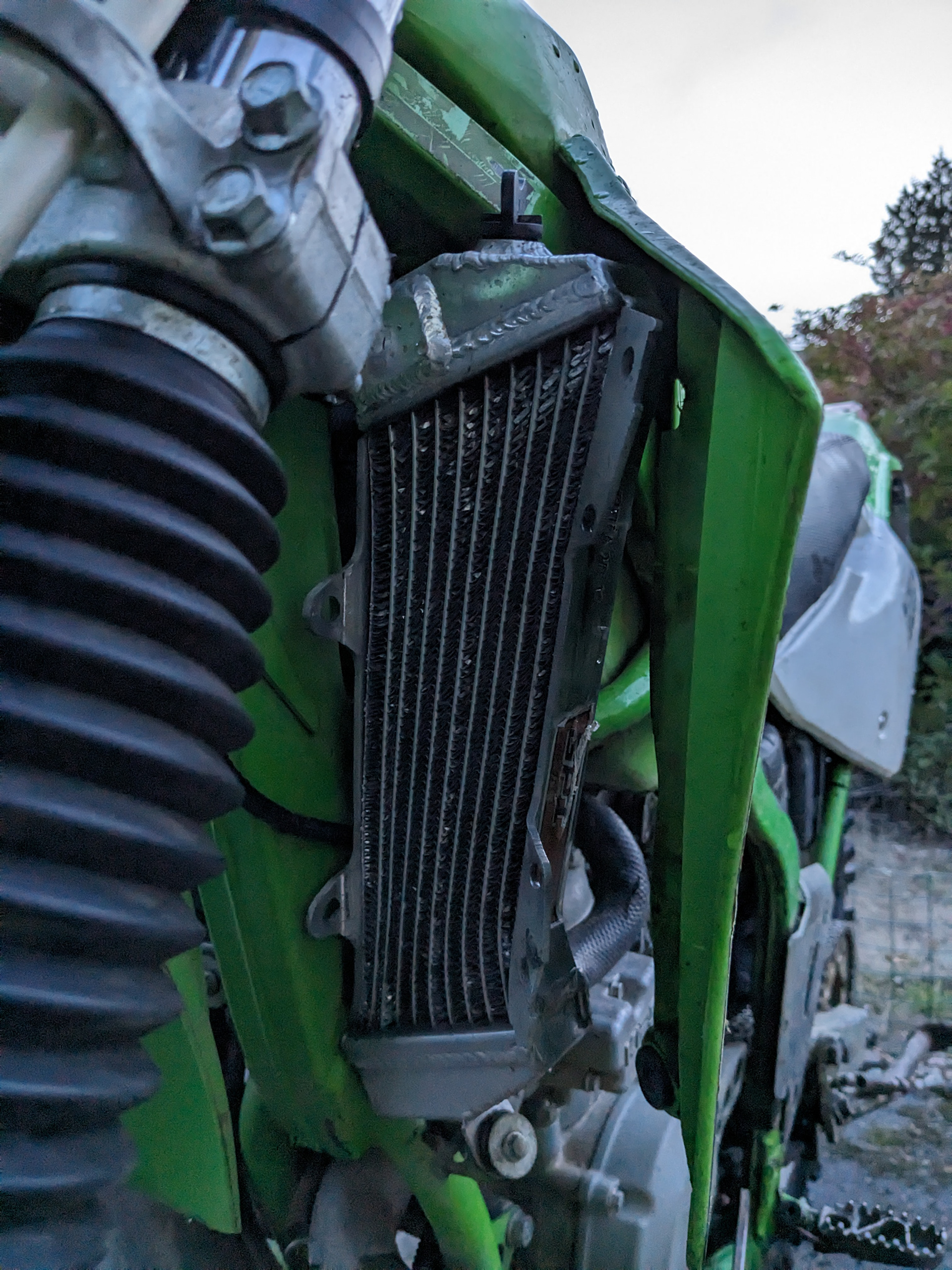 Tragic!  Dumped the bike and bent the radiator, caliper slide pin, and radiator mount.