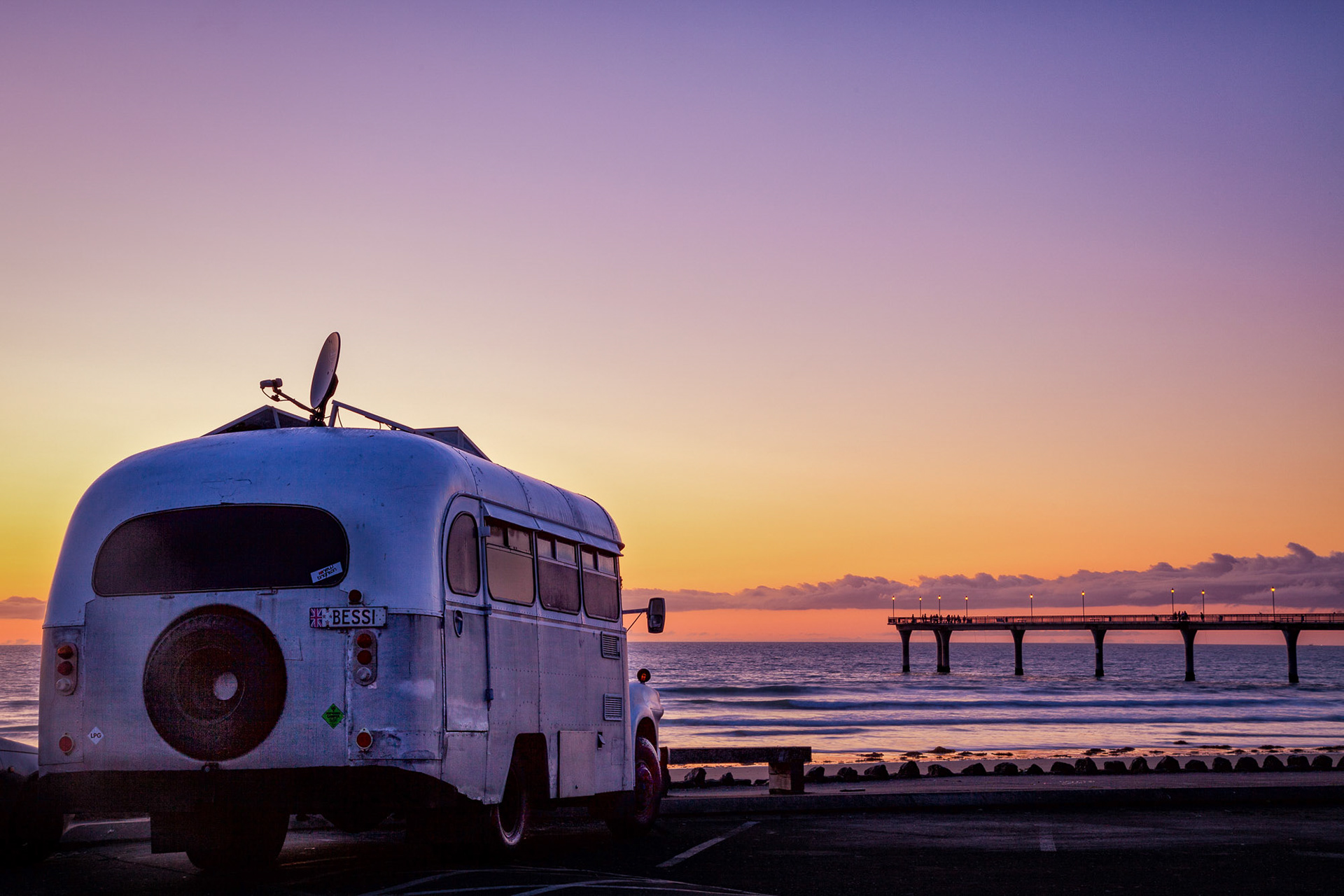 House bus "Bessi" parked up at the beach at sunrise, New Brighton Pier, Christchurch.