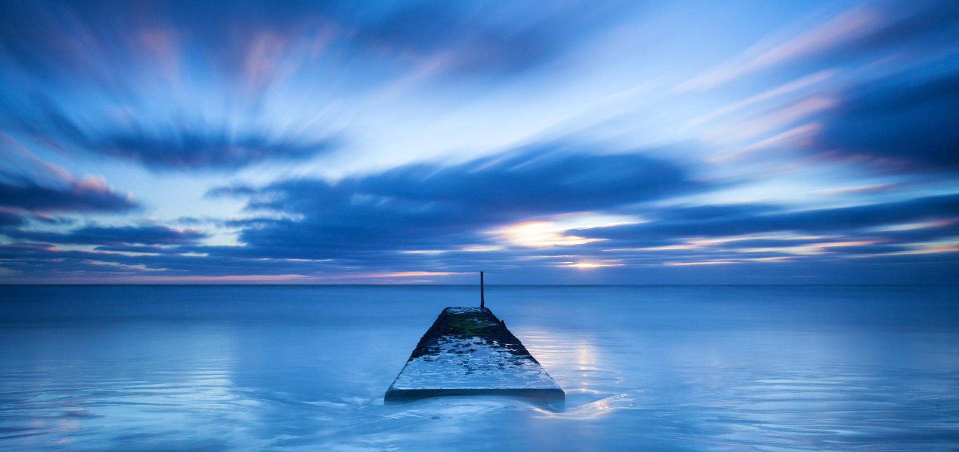 A blue hour pre-dawn long exposure image of a stormwater structure at Waimairi Beach, Christchurch. 
