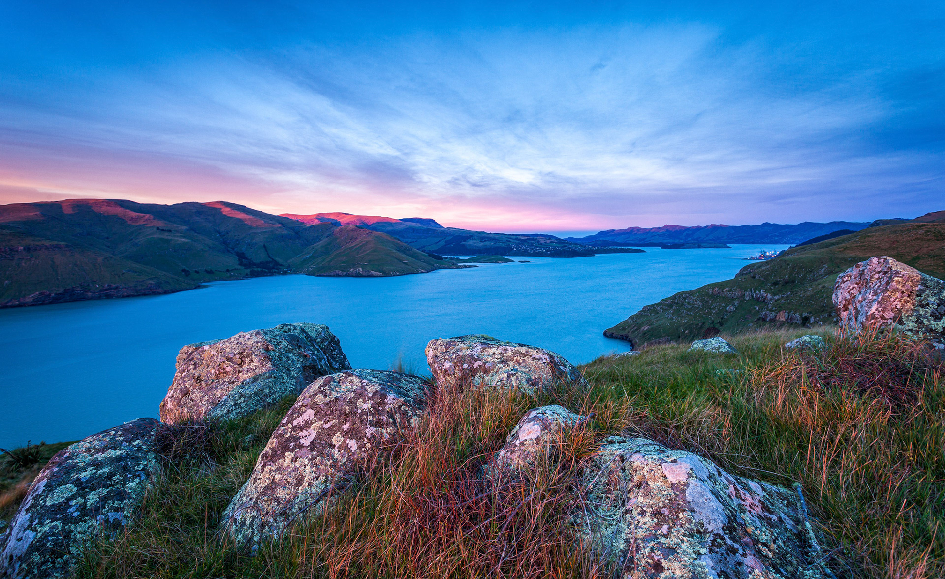 A sunrise image showing volcanic rocks looking toward the head of the Lyttelton / Whakaraupō Harbour