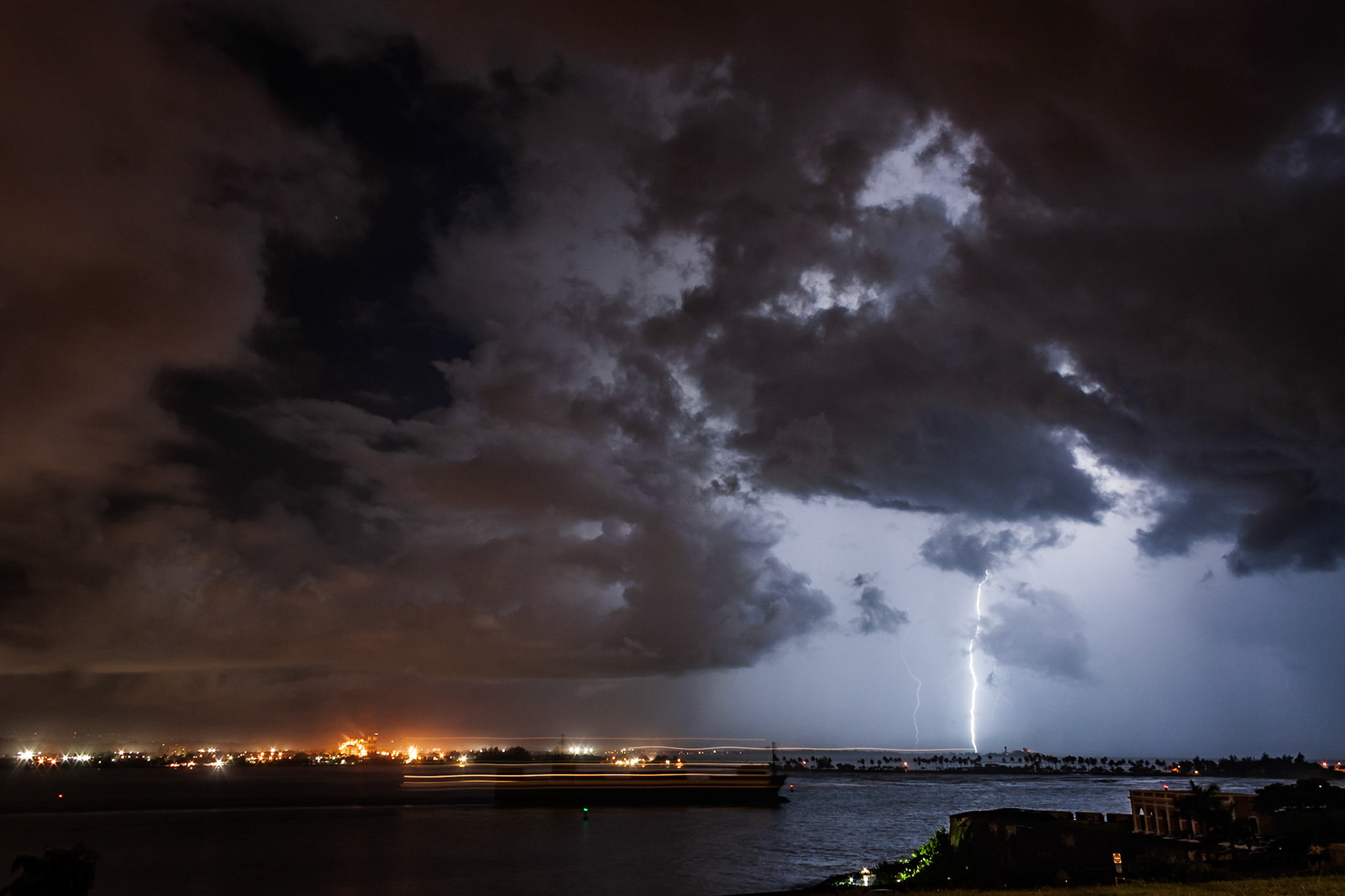 Una barco saliendo de la Bahía mientras cae un relampago. San Juan, Puerto Rico.
