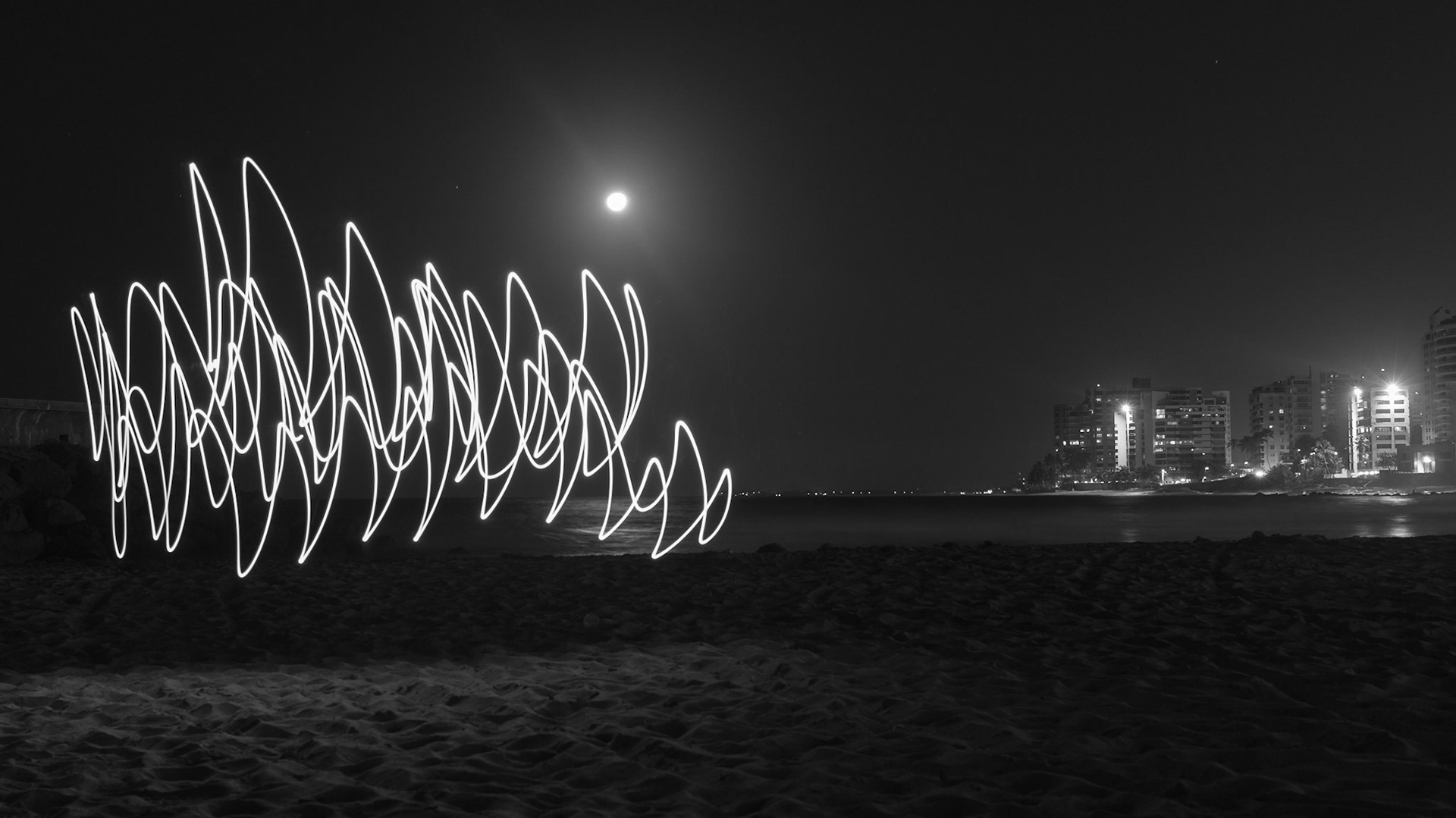 Trazos de luz bajo la luna, a la orilla de la playa de Condado. San Juan, PR.