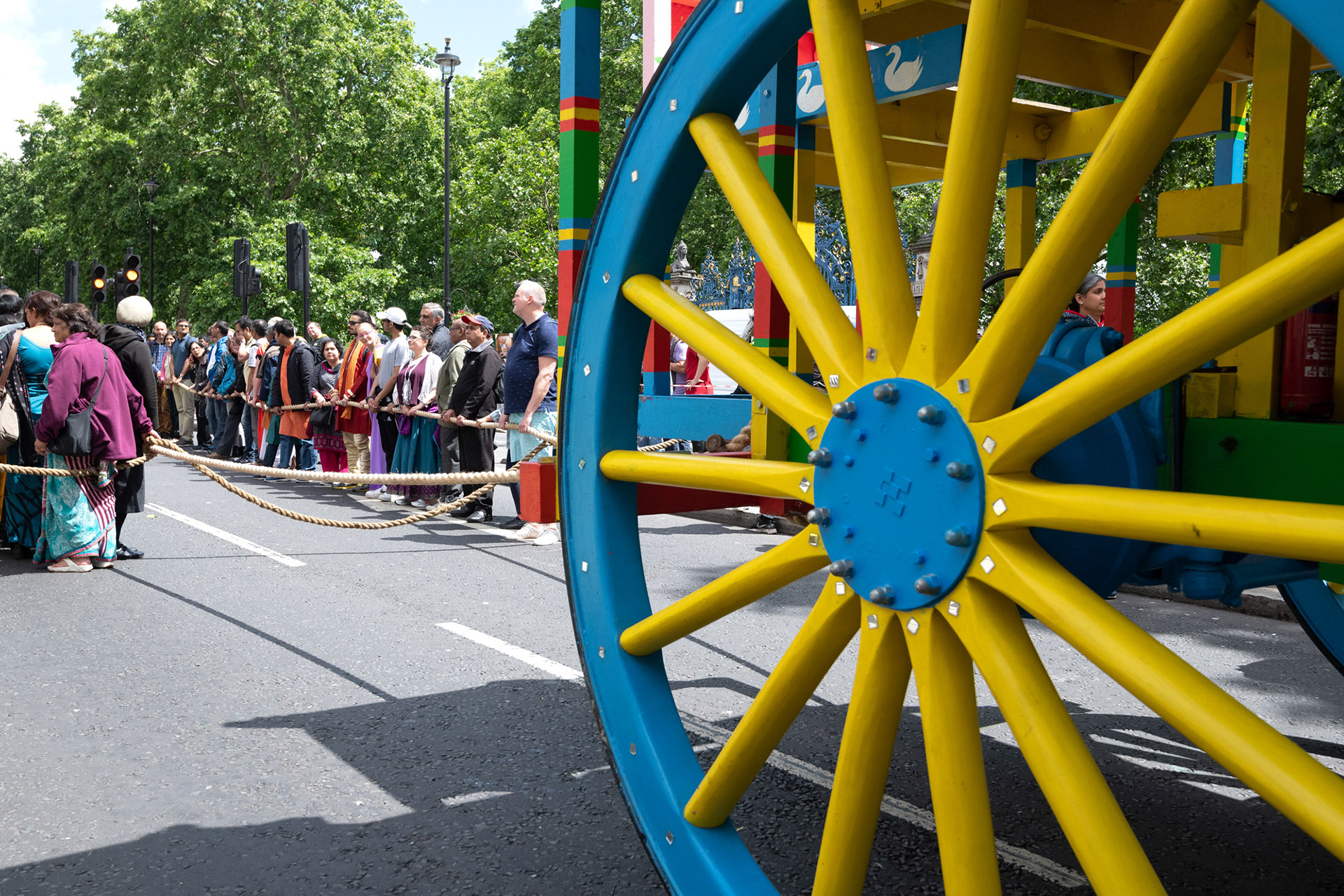 The wheel of a giant chariot being pulled along Piccadilly during the Hindu Ratha Yatra parade.
