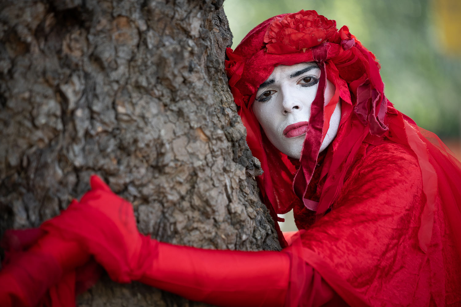 A Red Rebel Brigade member hugs a tree before joining an End Fossil Fuels protest march to Parliament Square. © Ron Fassbender