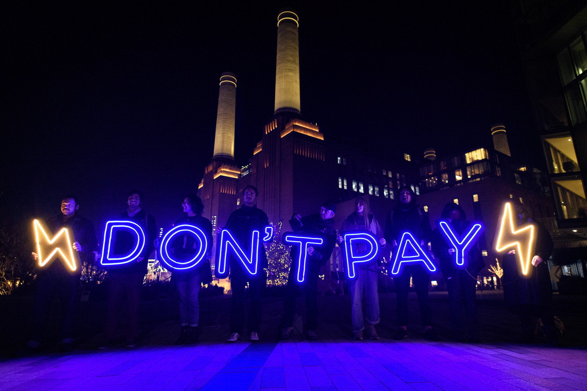 Neon light display outside Battersea Power Station urging people not to pay excessive fuel bills. © Ron Fassbender