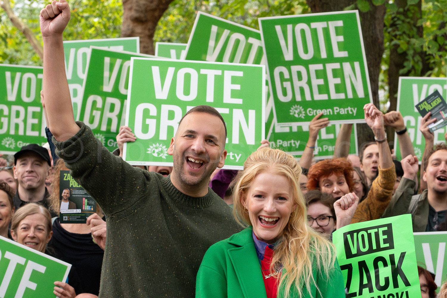 Green Party leader Zack Polanski with Green MP Hannah Spencer and supporters holding placards.