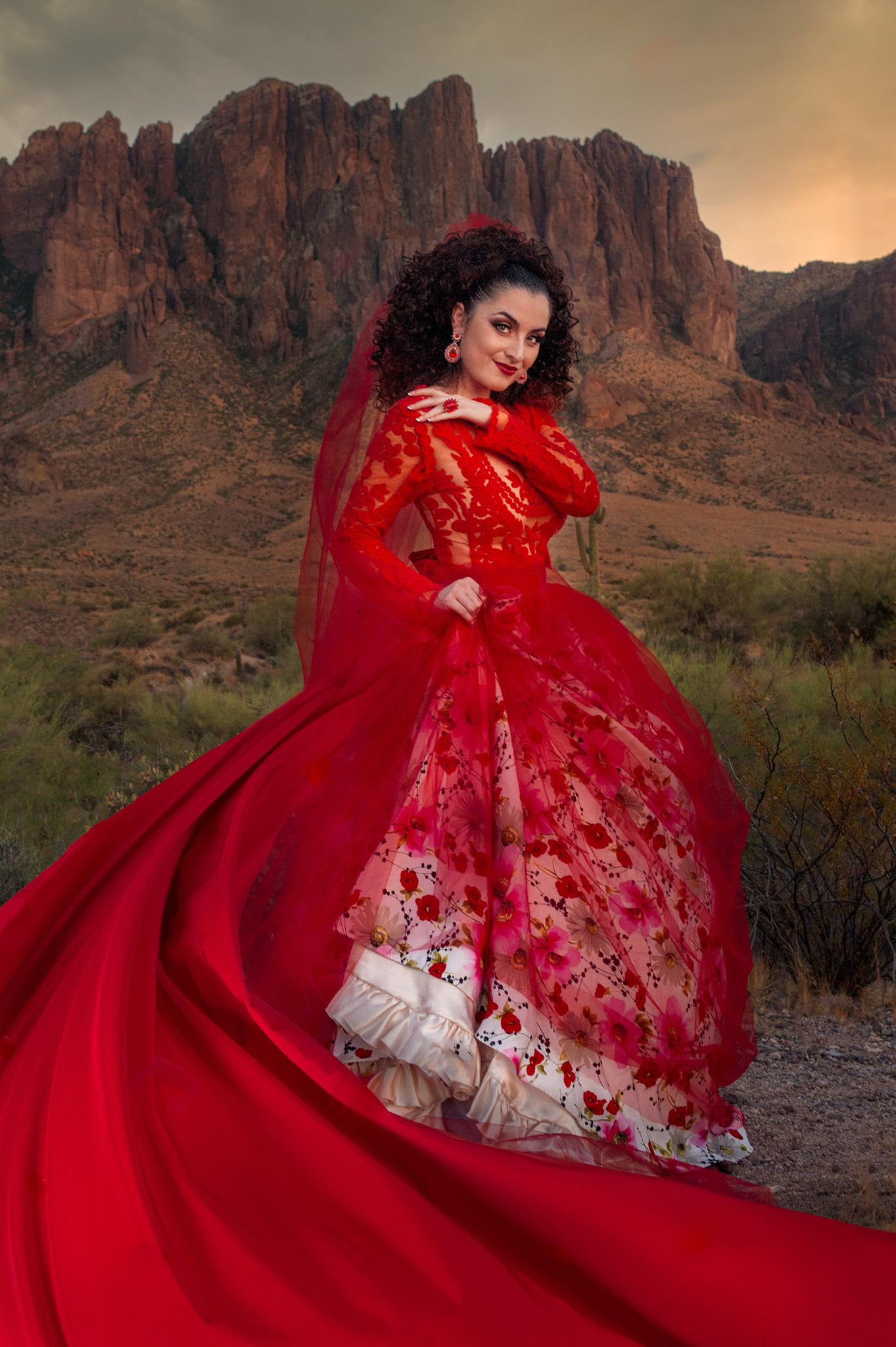 Cinematic editorial portrait of a woman in a red gown in the Arizona desert.