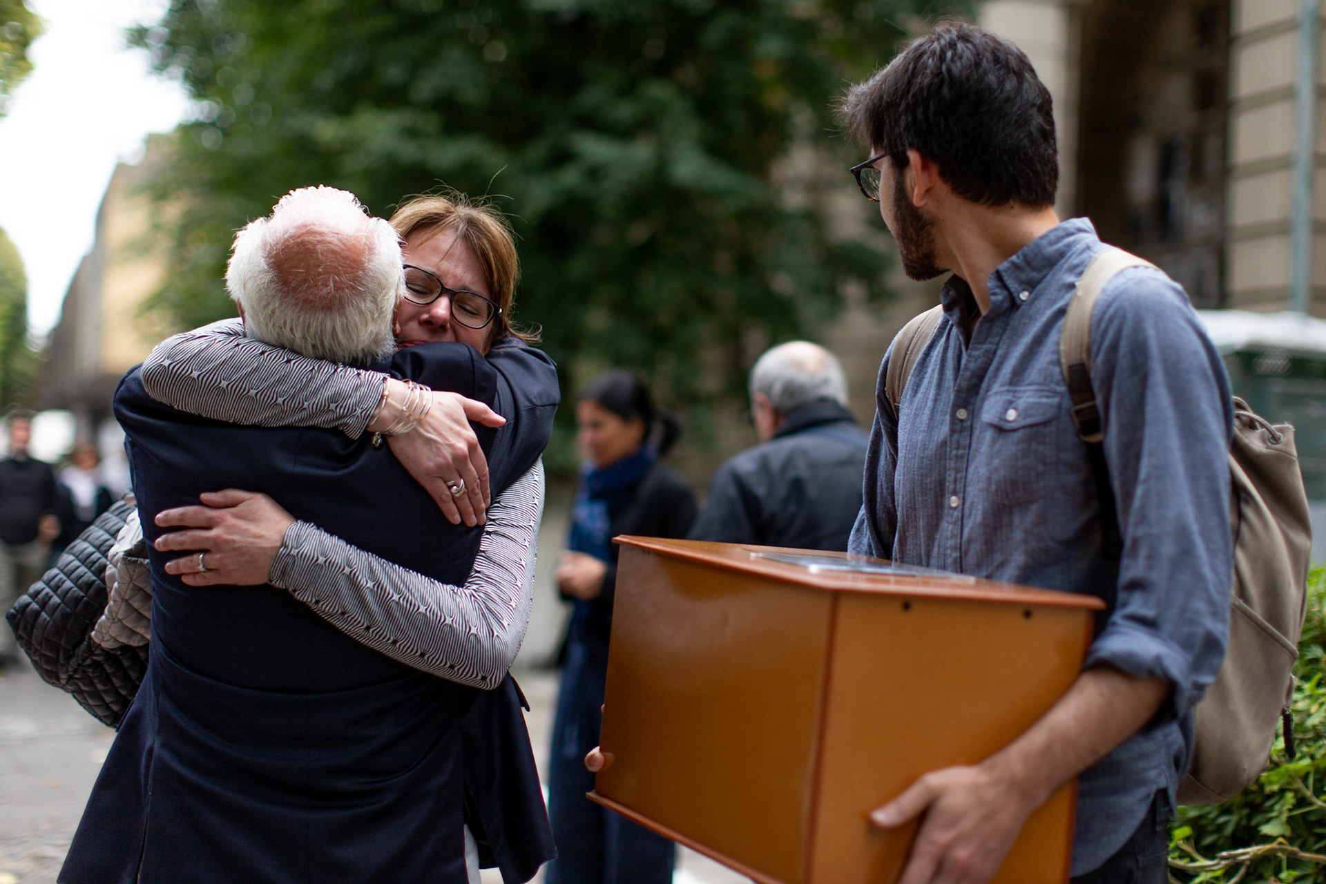 Bonnie Loedel, hugs her cousin while her brother, Daniel Loedel looks at her with their sisters remains in his hands at the La Plata Cementery in the city of La Plata, Buenos Aires.