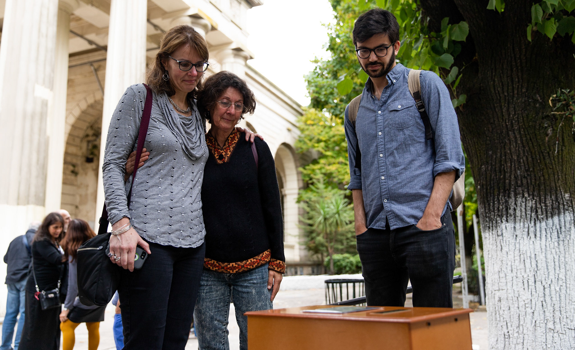 Bonnie Loedel and her brother Daniel Loedel look at their sister Isabel Celia Loedel Maiztegui’s remains next to a friend at the La Plata Cementery in the city of La Plata, Buenos Aires.