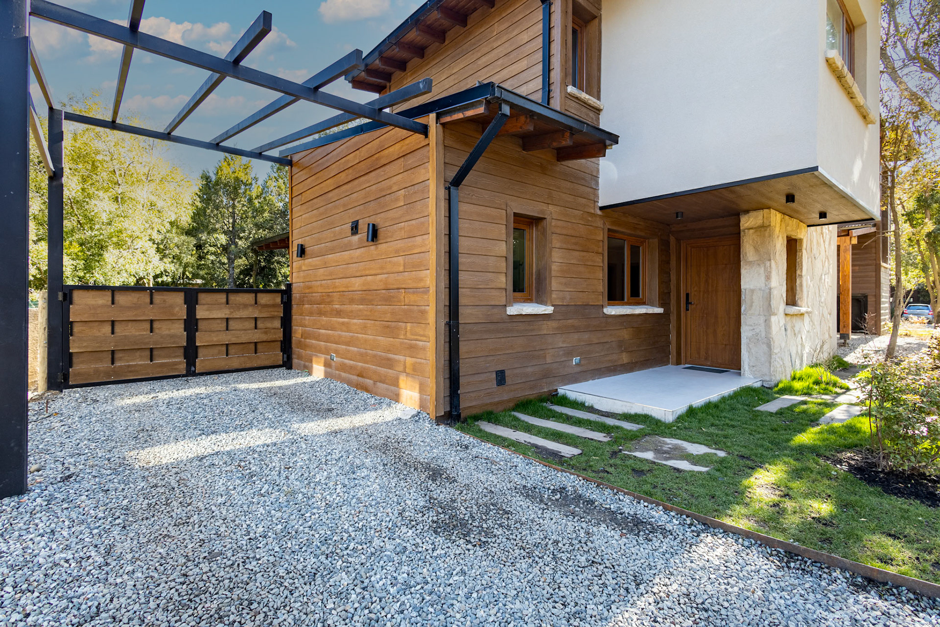 Fotografía de exterior de una casa con jardín y cochera con tres habitaciones que se alquila temporalmente en el barrio privado de Barrancas de Melipal en San Carlos de Bariloche.