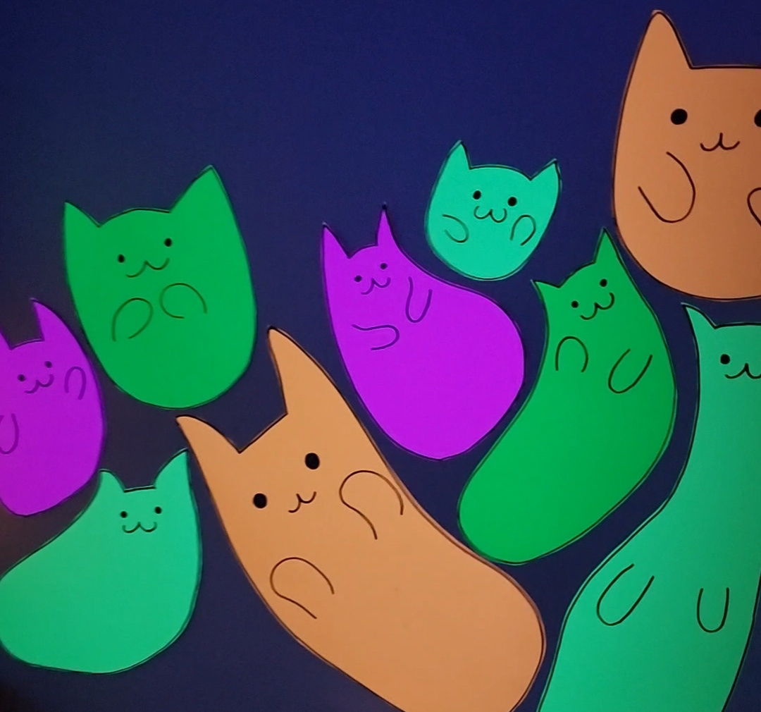 Cute gooey neon cat blobs used as wall decor.
