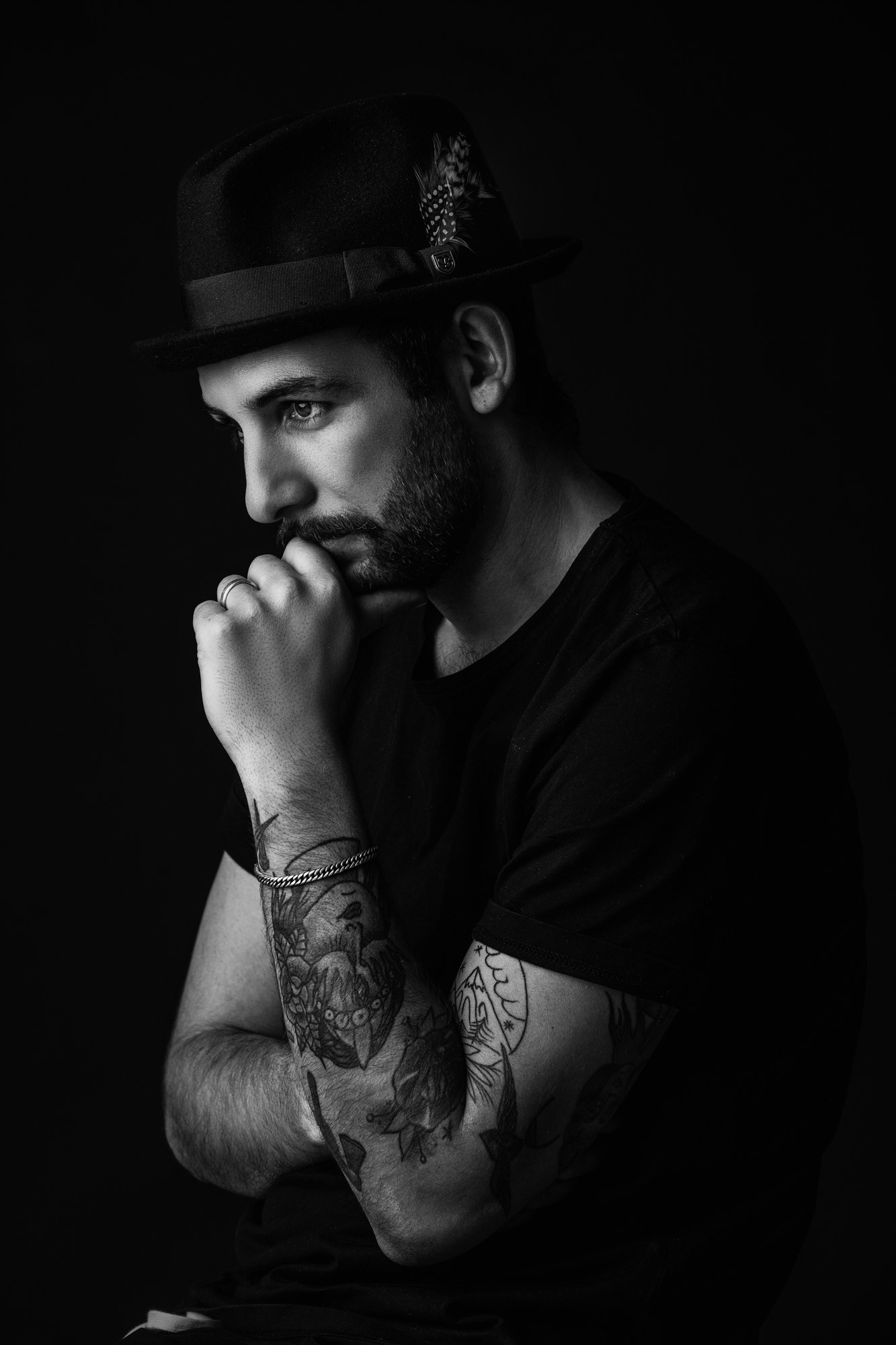 Schwarz Weiss Portrait Profil männliche Person nachdenklich mit Hut vor schwarzem Hintergrund