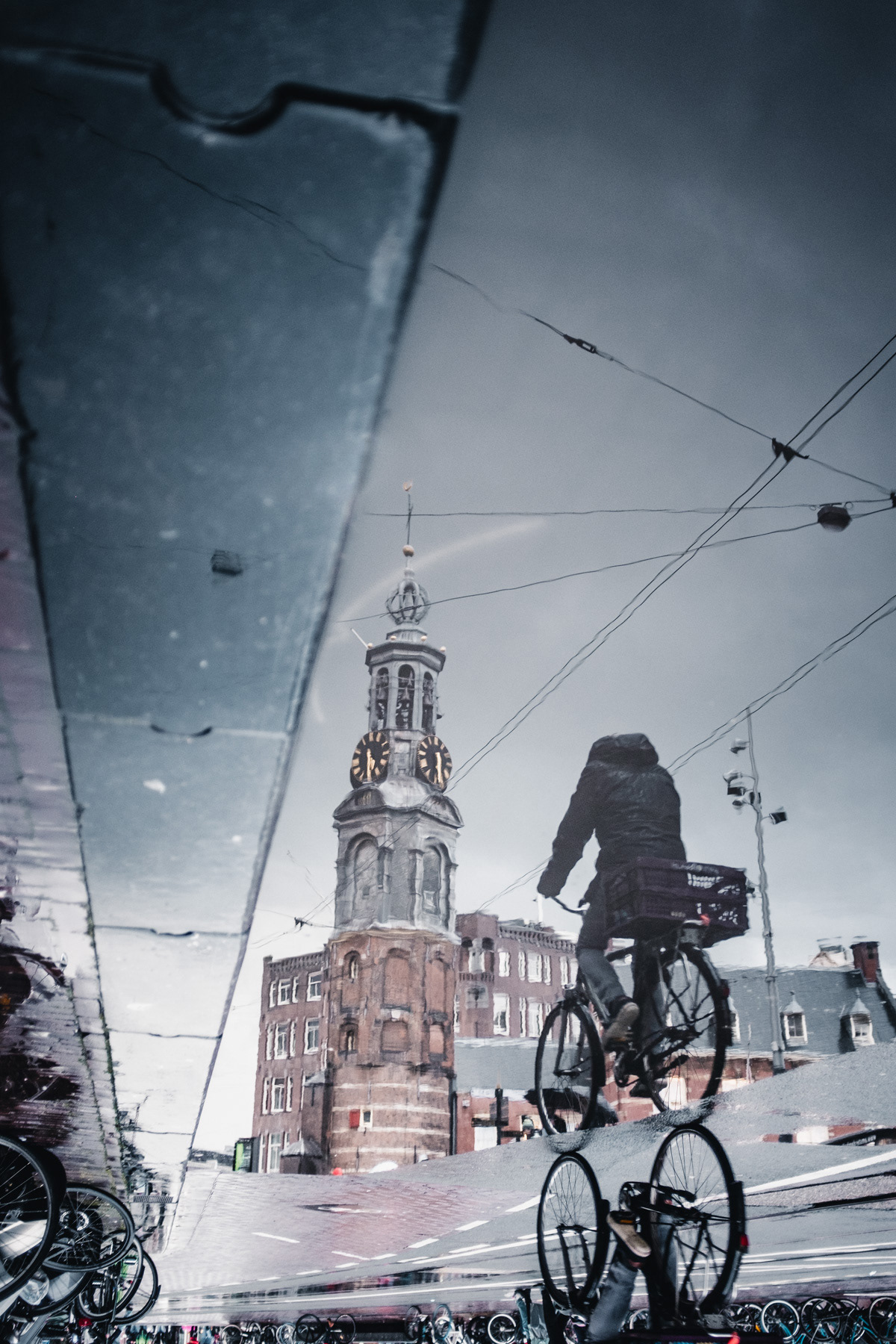 Fahrradfahrer in Spiegelung fotografiert mit urbanem Hintergrund in Amsterdam