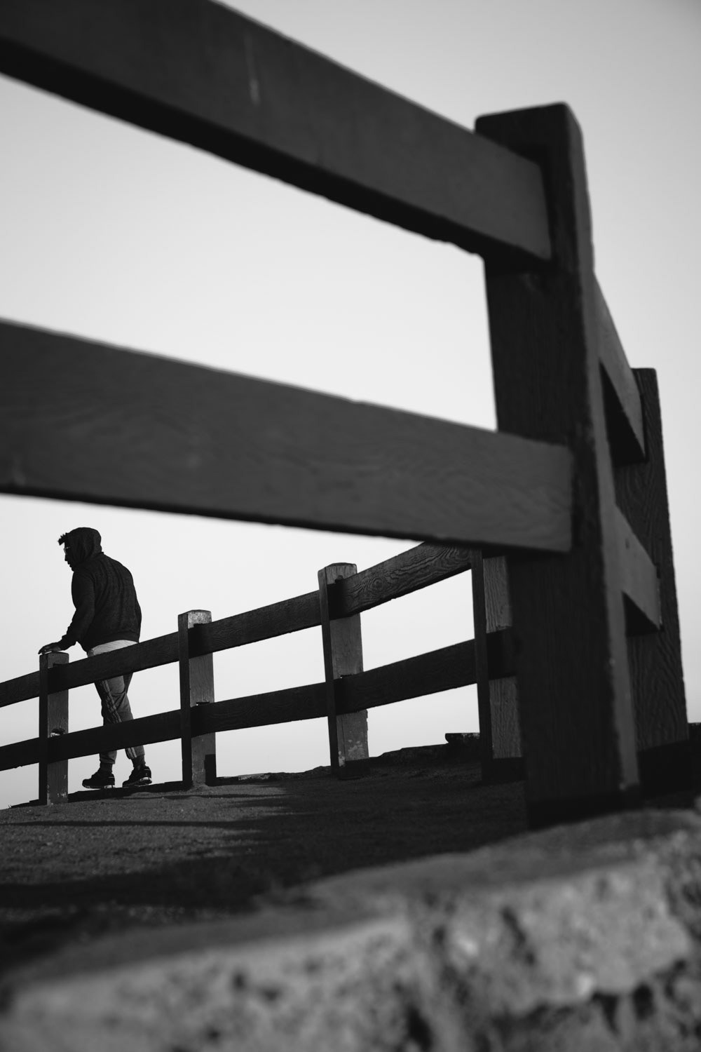 Schwarz Weiß Person läuft Zaun entlang