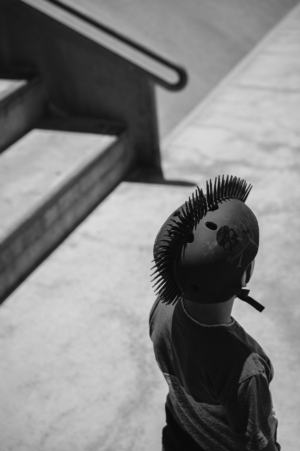 Schwarz Weiß Junge mit Irokesen Skateboard Helm in einem Skatepark