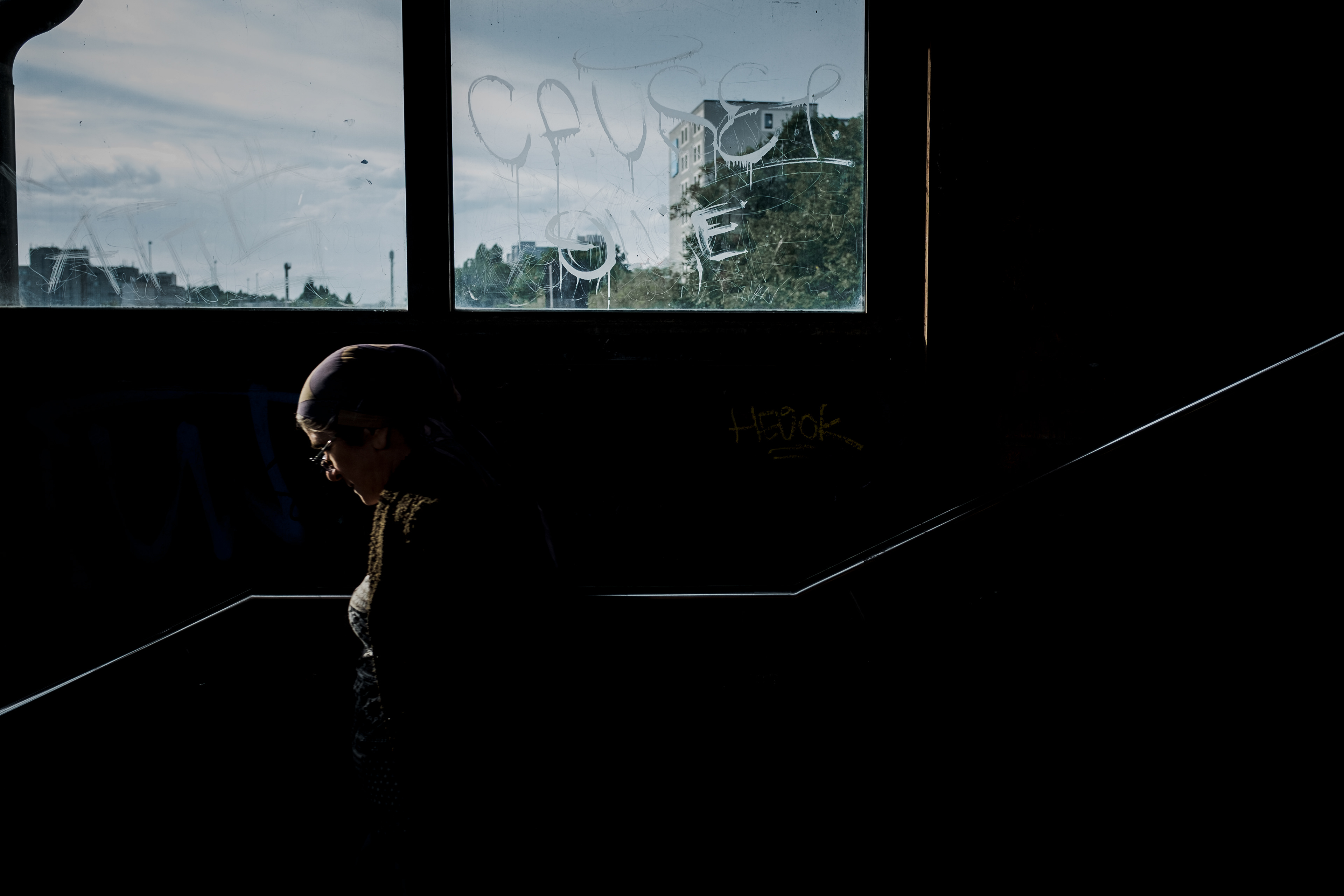 Person auf Treppe, nur Umrisse erkennbar, im Hintergrund Fenster mit aussicht