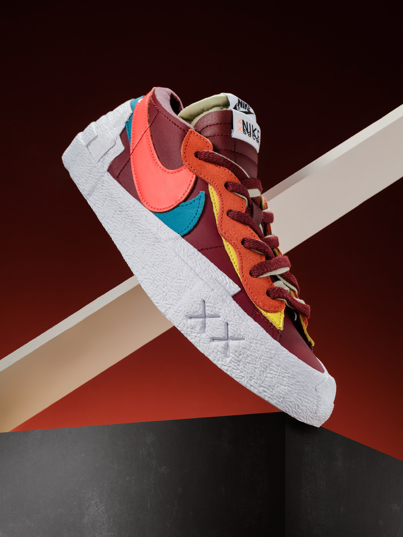 Produktfotografie eines Sneakers auf der Zehenspitze aufgestellt vor rotem Hintergrund