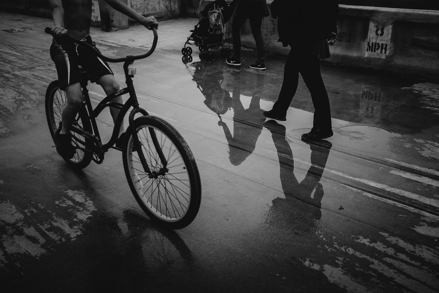 Schwarz Weiß Wasserpfütze mit Fußgänger, Fahrradfahrer und Kinderwagen