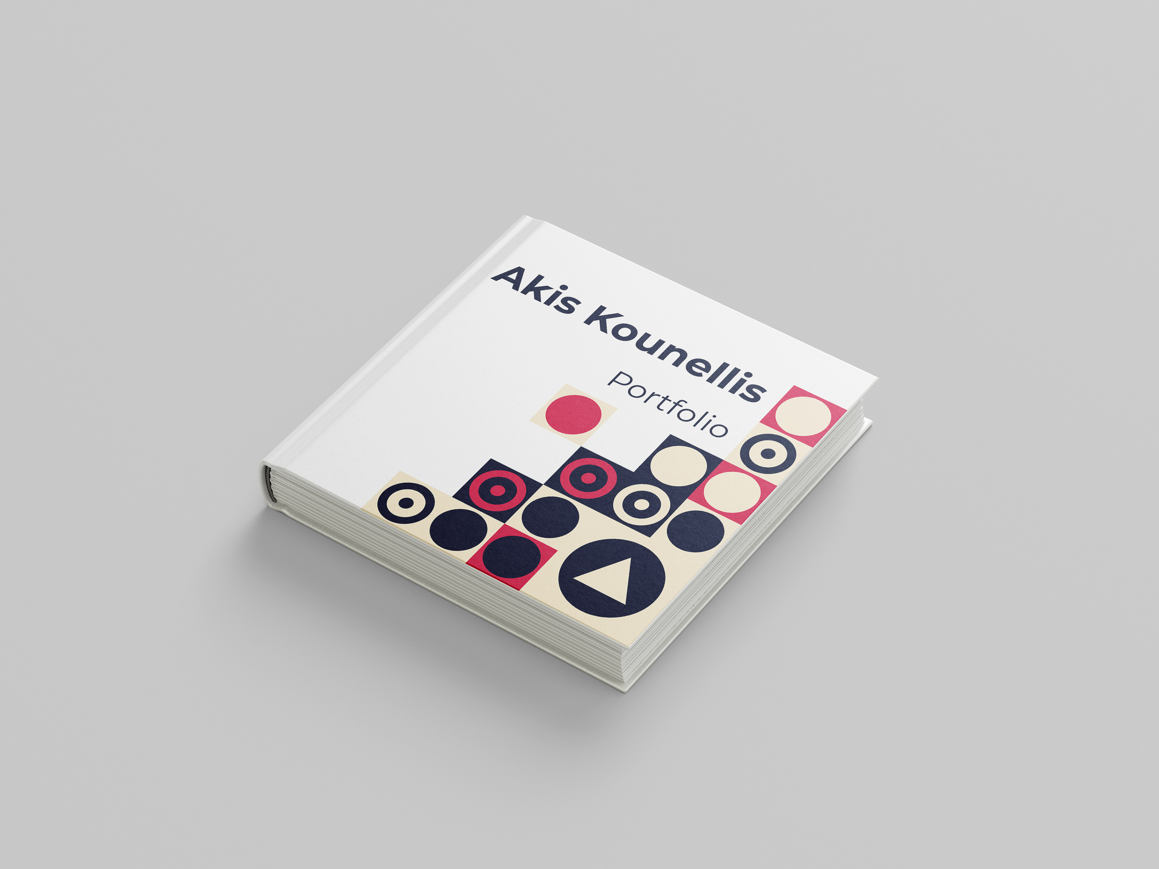 Hardcover portfolio book by Akis Kounellis with white cover, geometric red, black, and beige patterns, and bold modern typography.