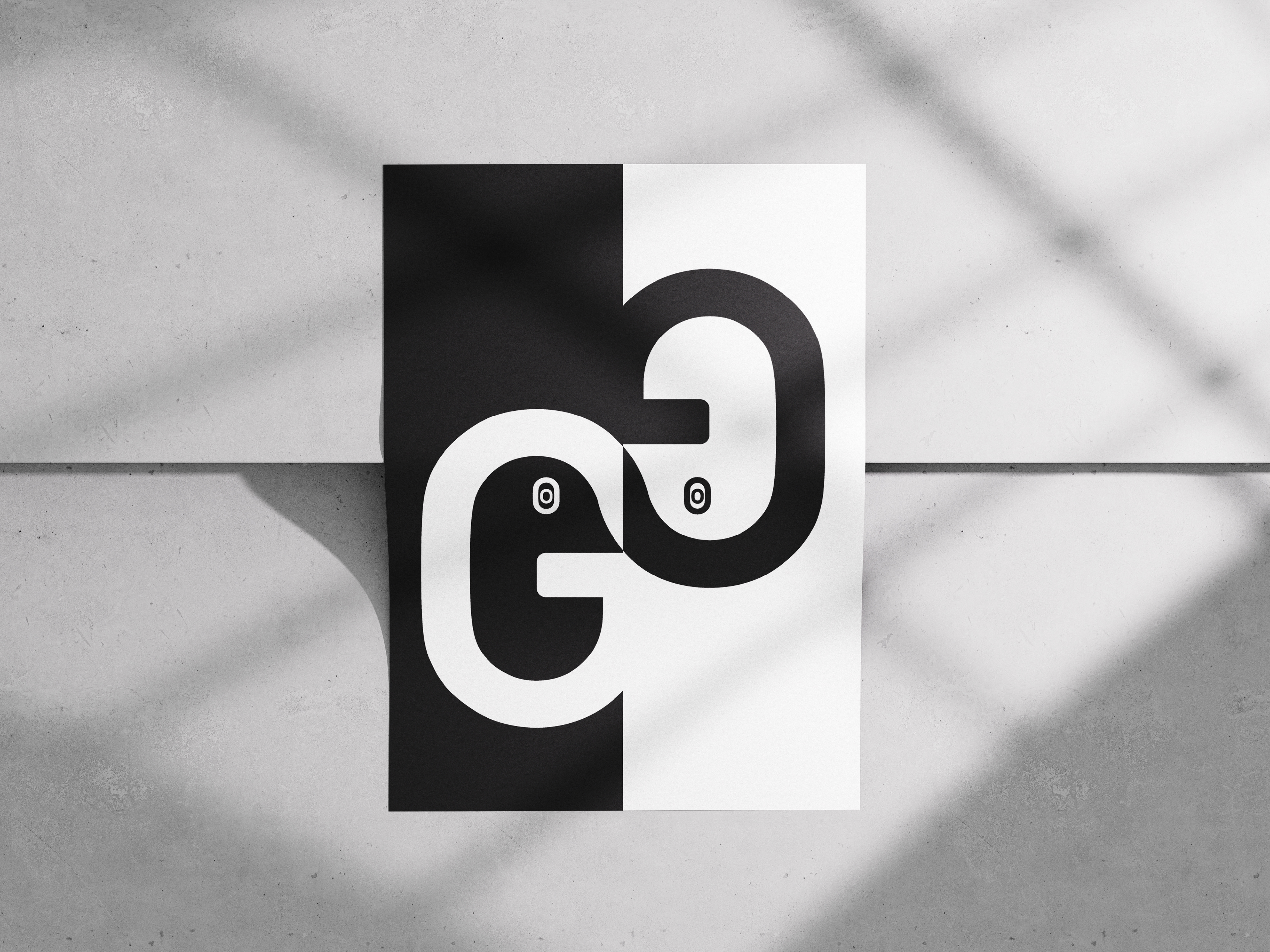 Black-and-white typographic poster with mirrored G and g, high-contrast split design, and eye-like details adding anthropomorphic character.