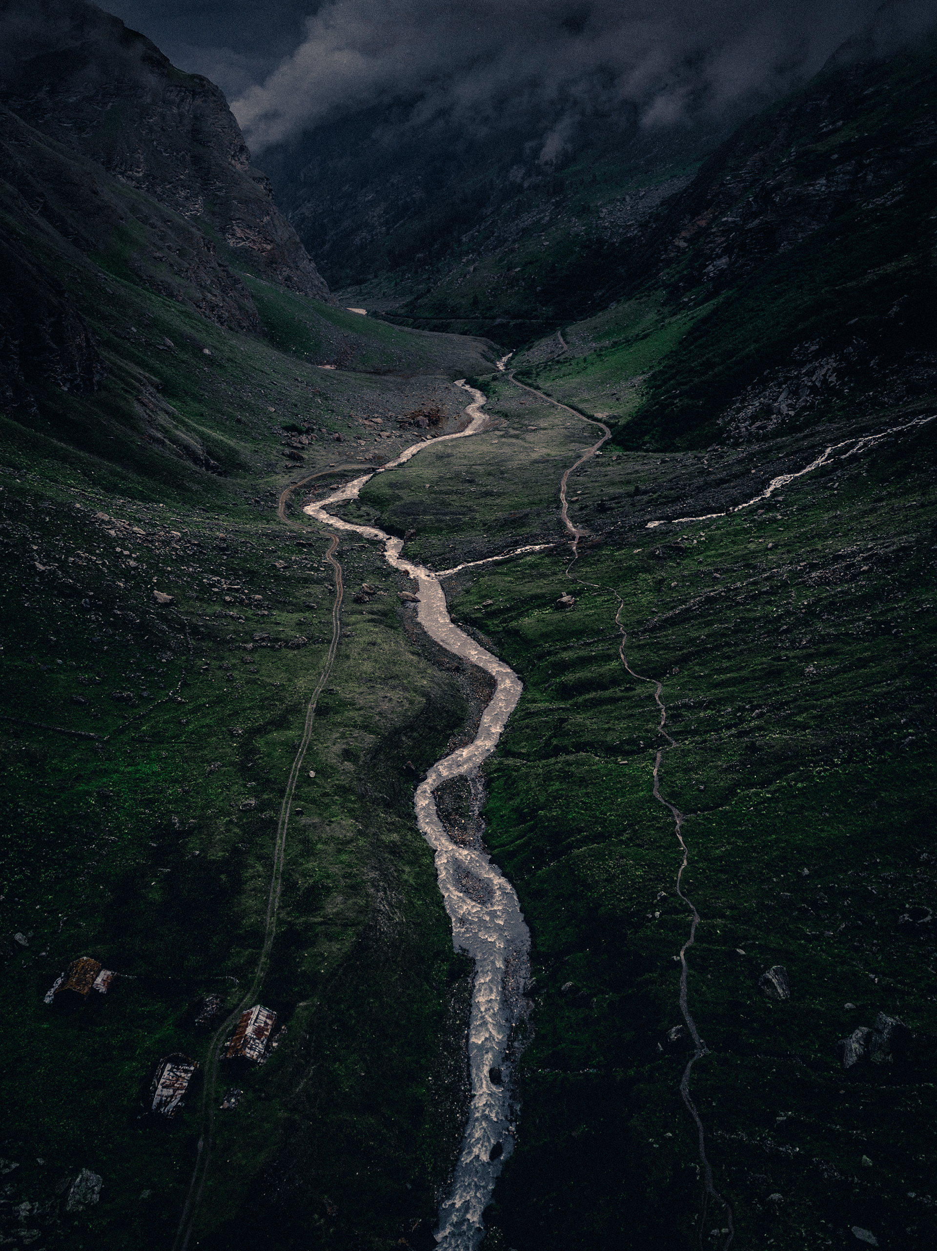 Winding stream flowing through green mountain valley.